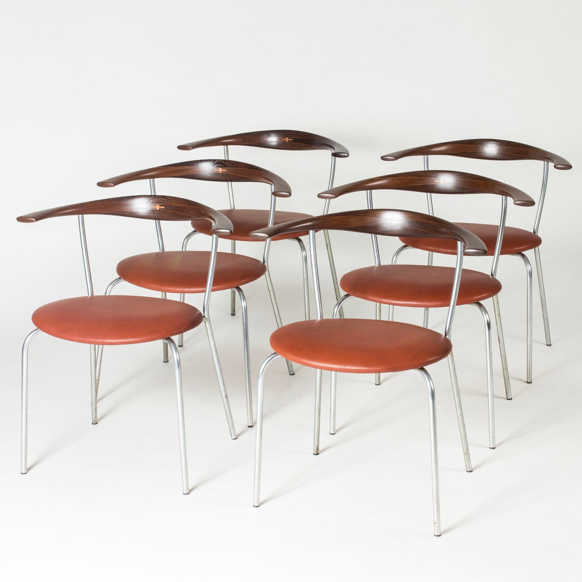 Set of six stunning “JH 701” dining chairs by Hans J. Wegner. Steel legs, cognac leather seats and sculpted wenge backrests. Contrasting wood detail in the backrests.