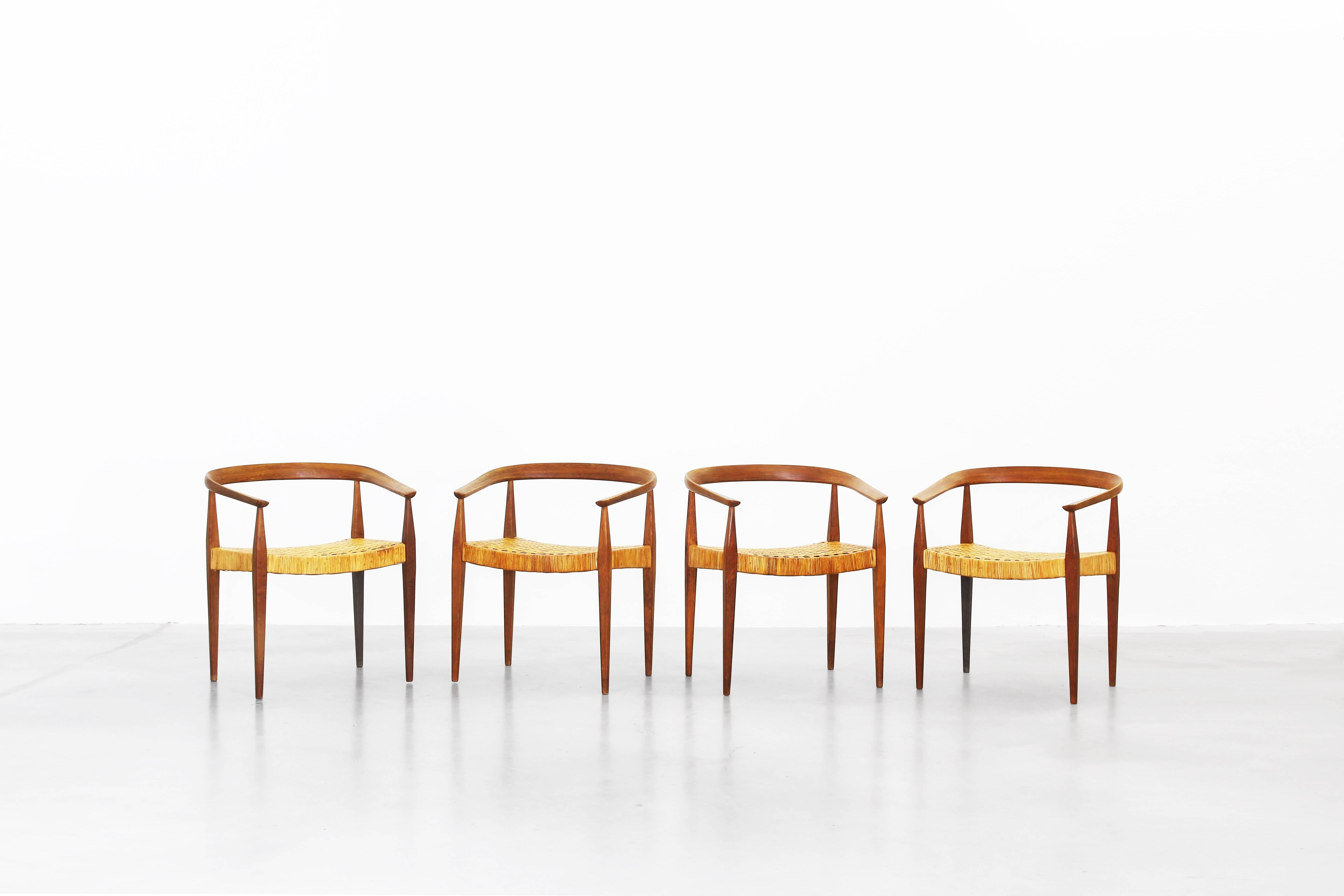 A beautiful set of ten armchairs designed by Nanna Ditzel for Poul Kold Savaerk in 1955, made in Denmark. All chairs come with a great patinated oak and cane and are in an excellent condition with little traces of usage.