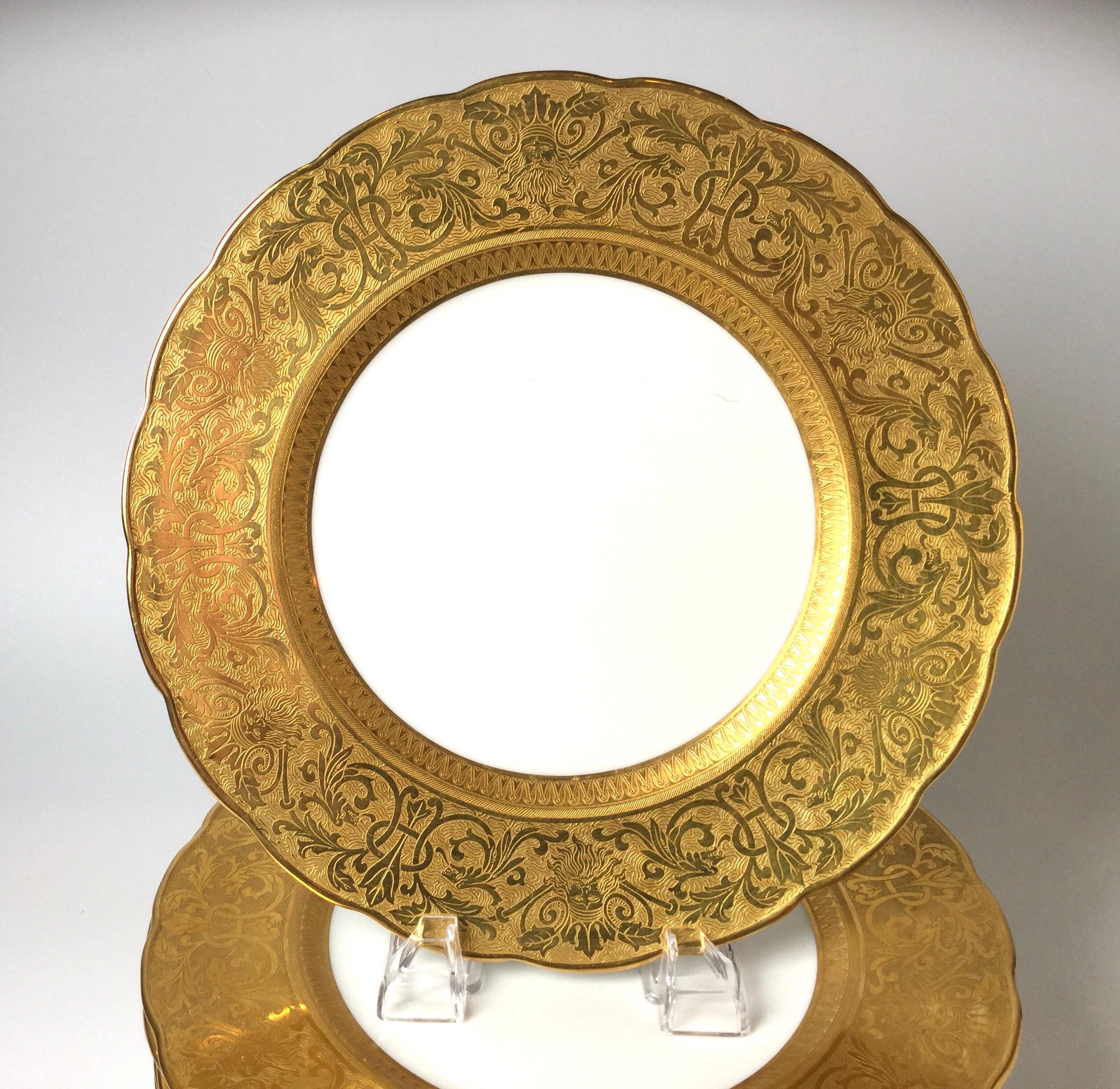 Set of ten outstanding gold embossed figurative head service plates. Thick luxurious gold band border with white porcelain background.
