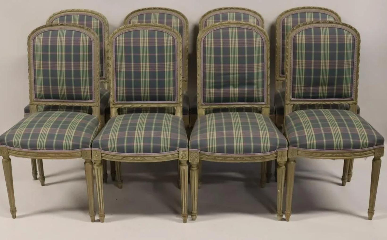 A set of 10 French Louis XVI style dining chairs with arch backs and fluted legs, painted and carved wood with plaid upholstery. The upholstery on the seat and back is accented with complementary lavender trim. 