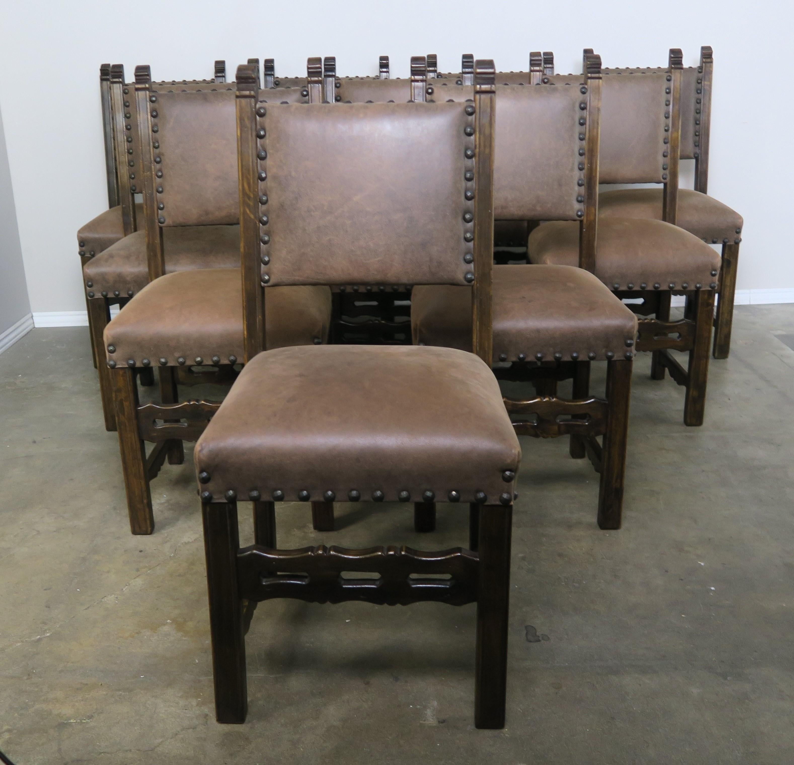 Set of ten Spanish style dining side chairs upholstered in brown leather with nailhead trim detail.
Measures: seat height 22