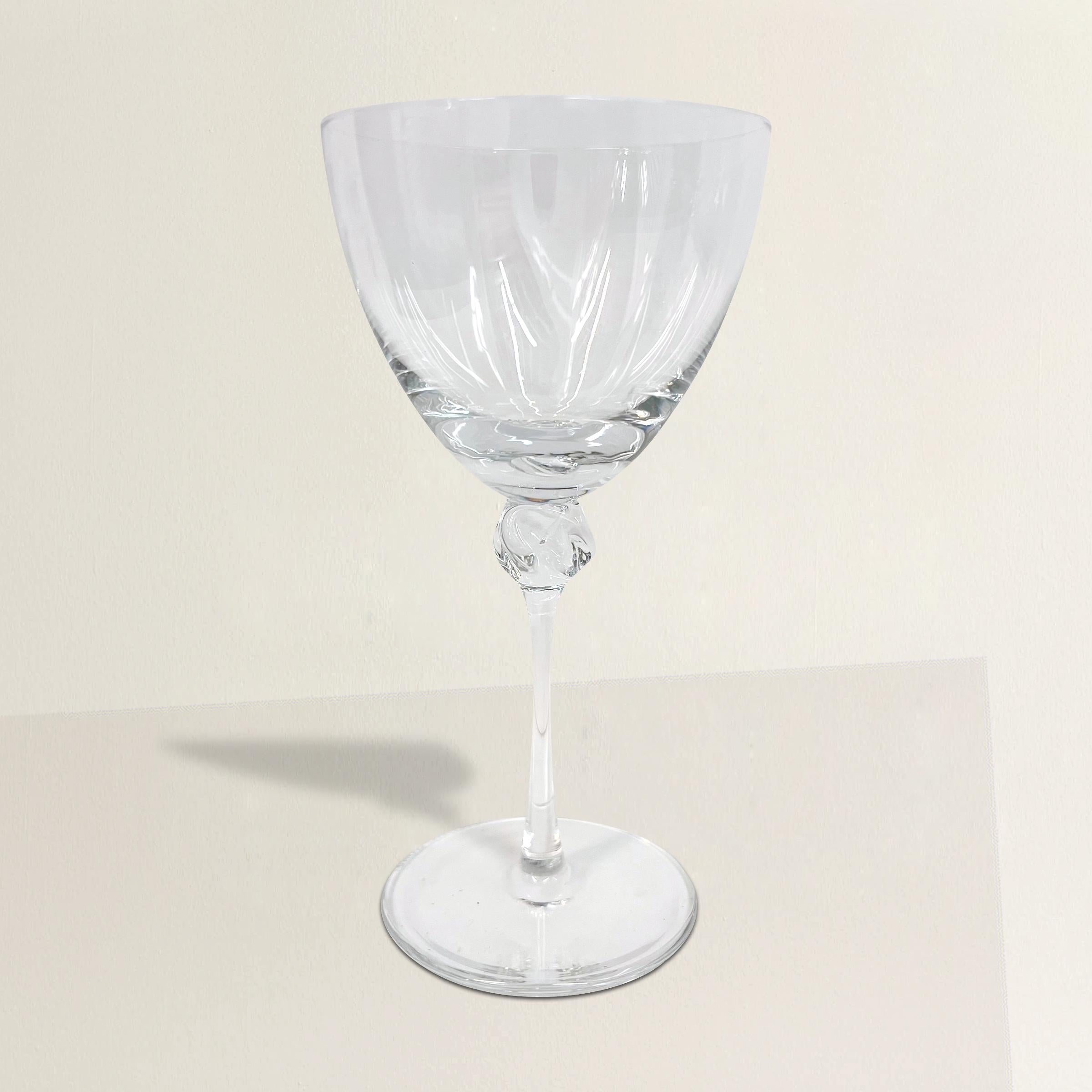 A chic and sophisticated set of ten vintage French wine goblets by powerhouse crystal studio, Daum, each with whisper thin bowls and stems joined by an elegant slumped and swirled crystal knuckle. Signed on the bottom of each foot. Perfect for your