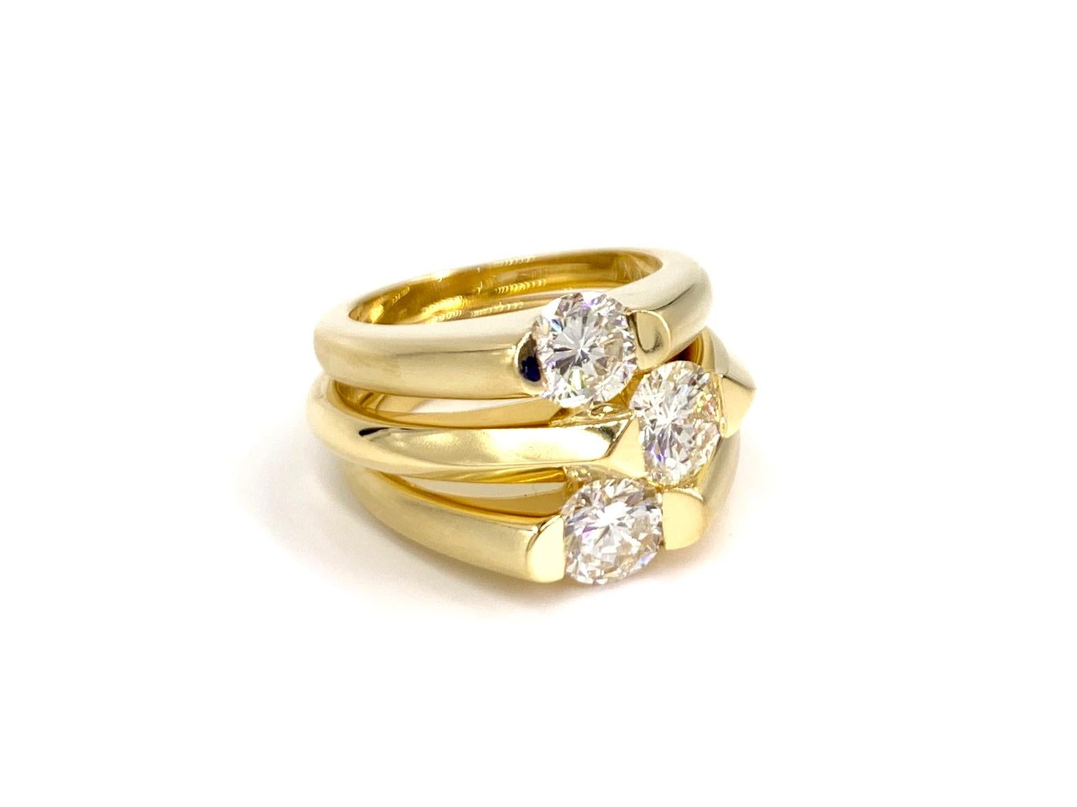 A simply stunning set of three solid 18 karat yellow gold solitaire rings made in a unique yet clean design at 2.32 carats total weight. Diamond weights are stamped inside each ring - .85 carat, .77 carat and .70 carat. Diamond quality is