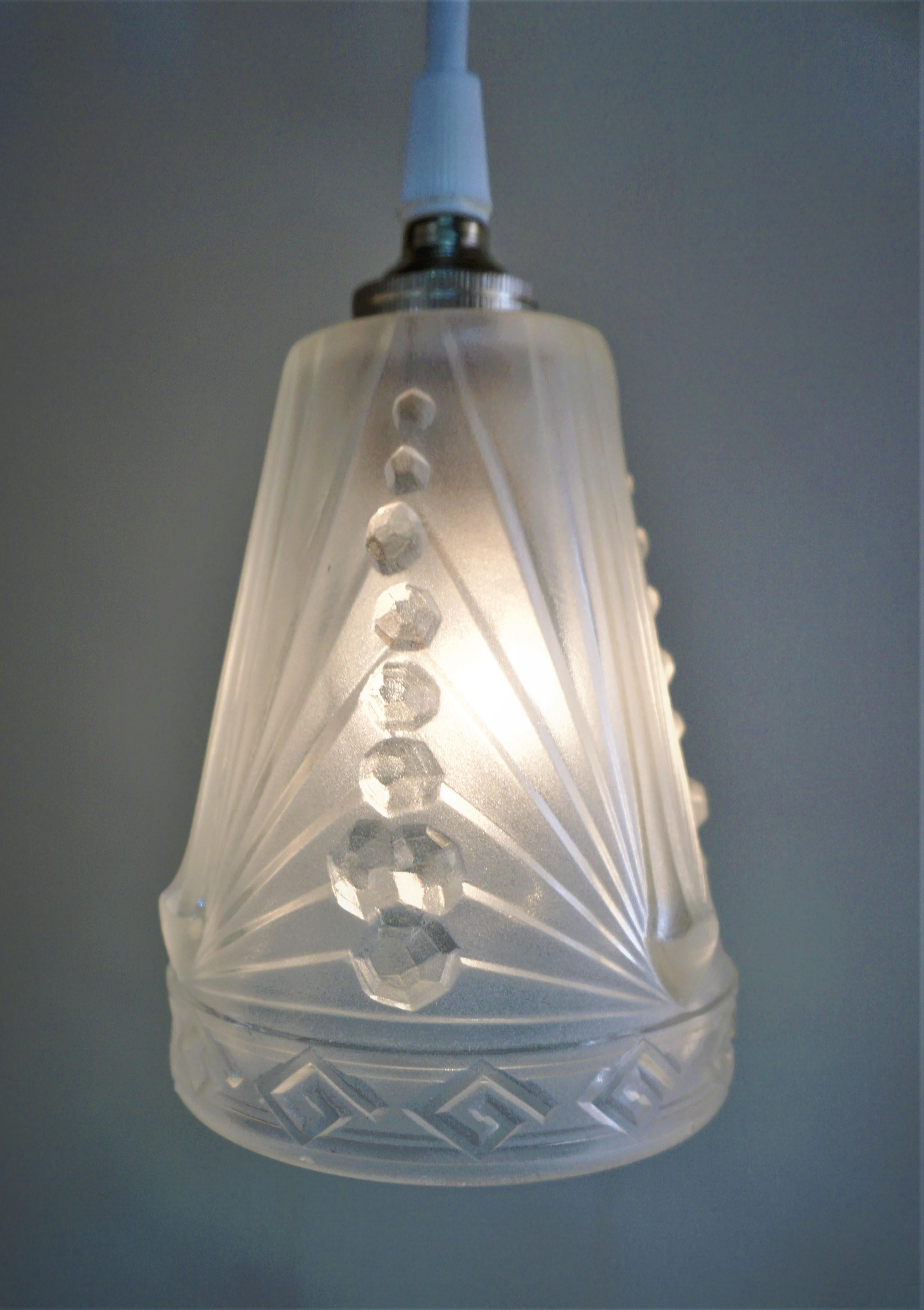 Set of three 1930s Art Deco glass shades by Charles Schneider that have been modified with new white cord and nickel canopy as pendant lights.

Price is for set of 3.