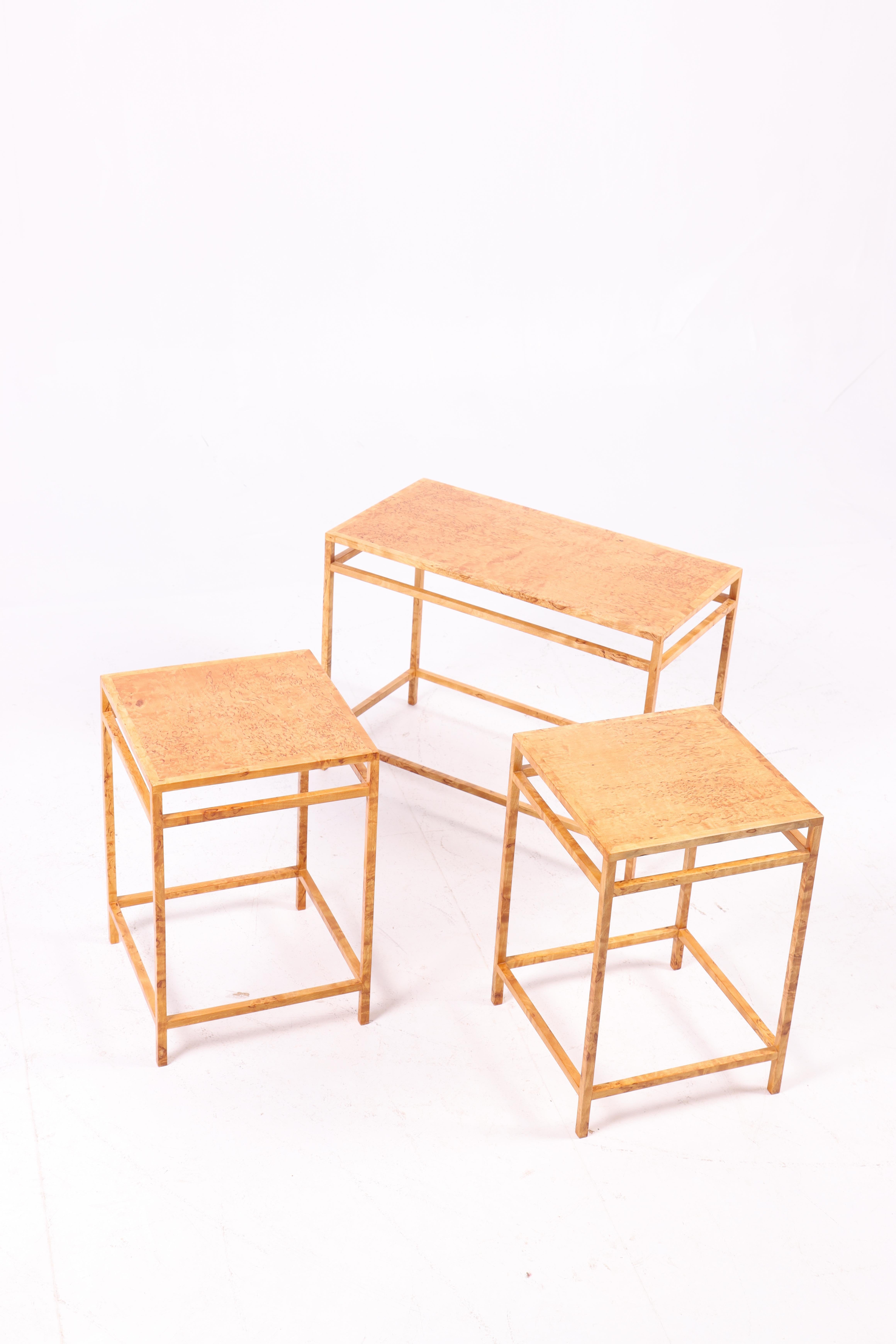 These three side tables from the 1960s are crafted from birdseye maple, known for its beautiful and distinctive grain pattern featuring small, round knots resembling bird's eyes. The tables have a simple, minimalist construction that allows the