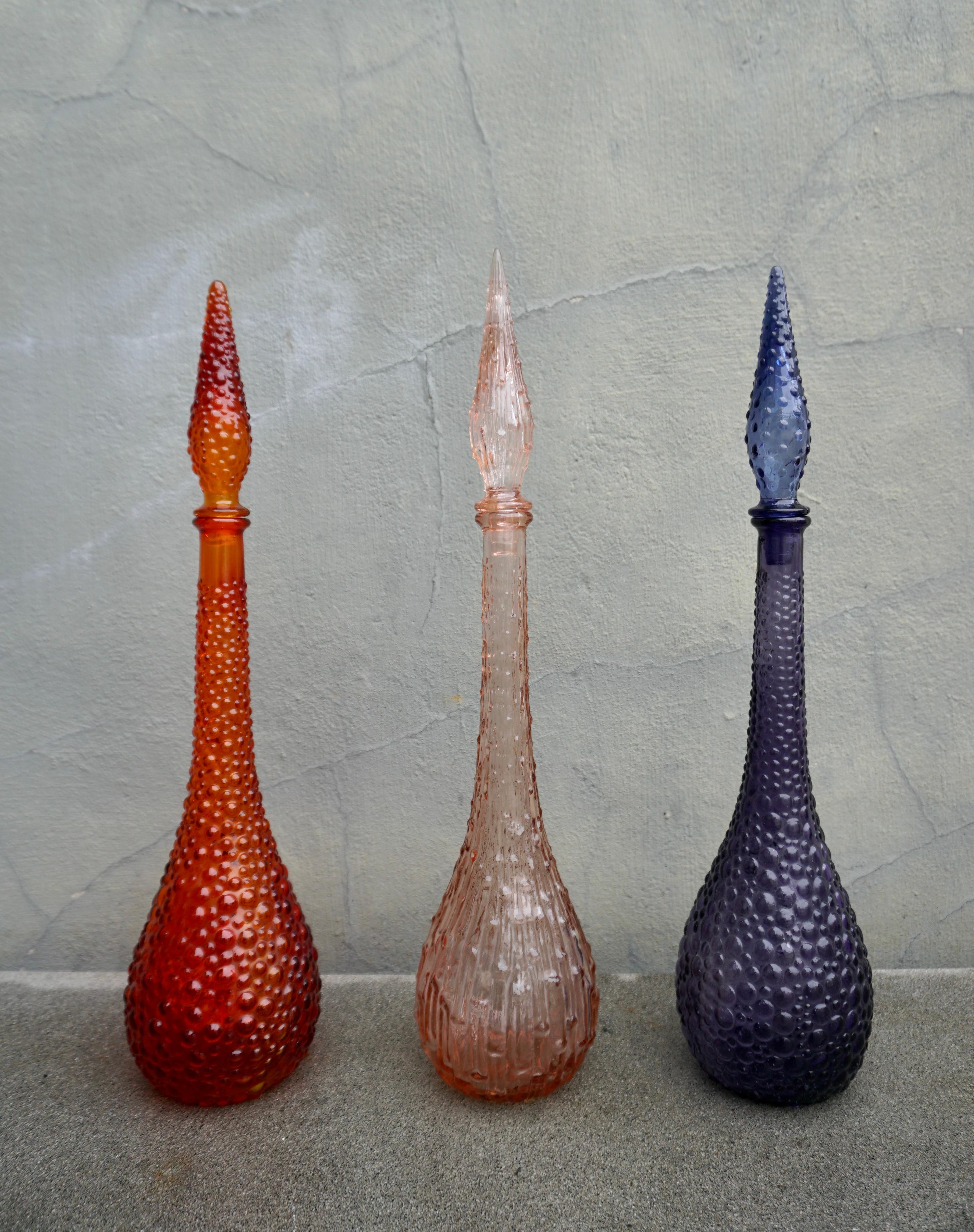 Spectacular set of three 1960s Italian Empoli pressed and blown glass genie bottles. 

Mention Italian glass and probably everyone’s mind immediately leaps to Venice and Murano.  But there is another almost equally famous centre of Italian glass