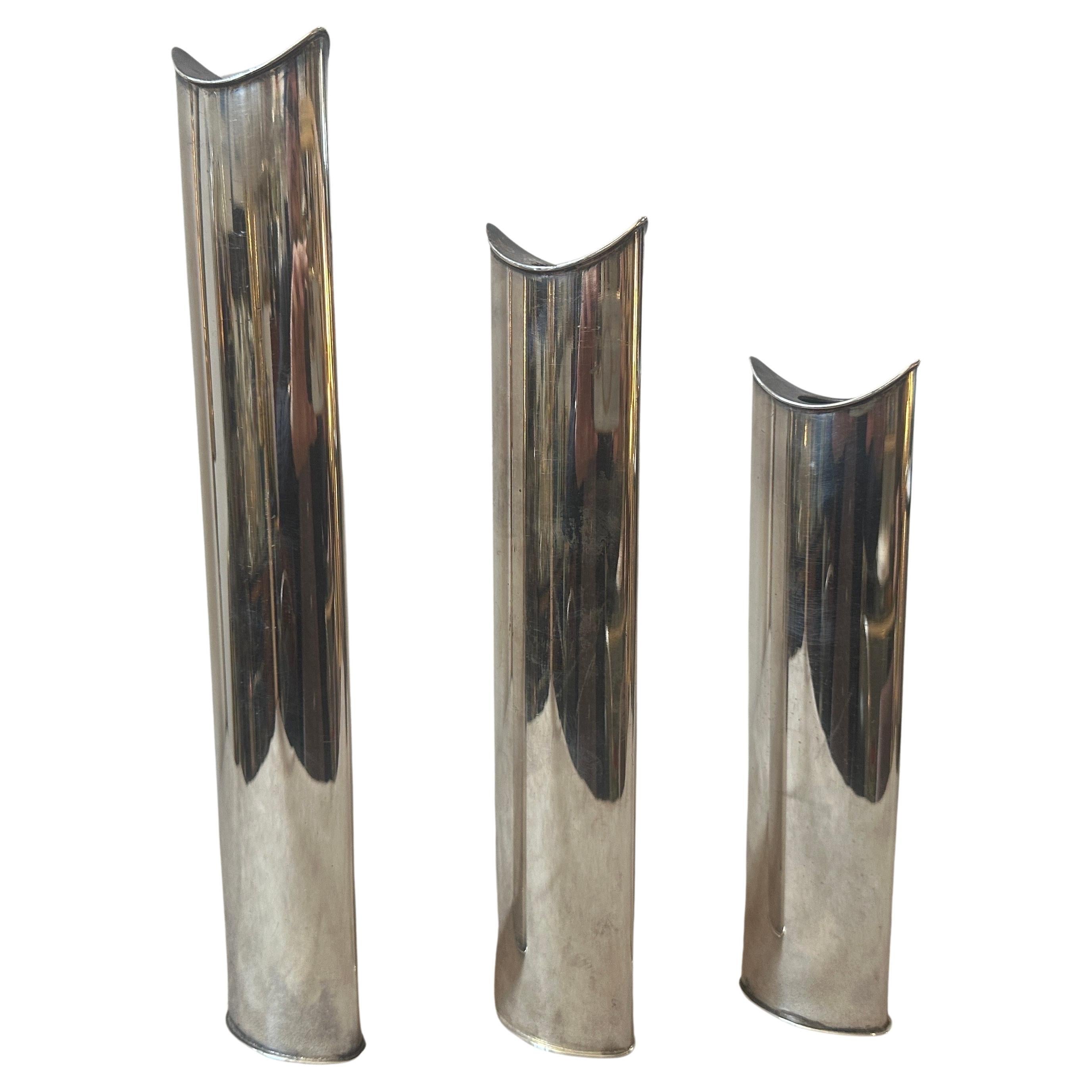 Three iconic silver plated Giselle Vases also usable as candlesticks designed by Lino Sabattini and produced by Sabattini Argenteria. Heights of the other two vases are cm 26 and cm 21. They are in perfect conditions. Lino Sabattini is an Italian