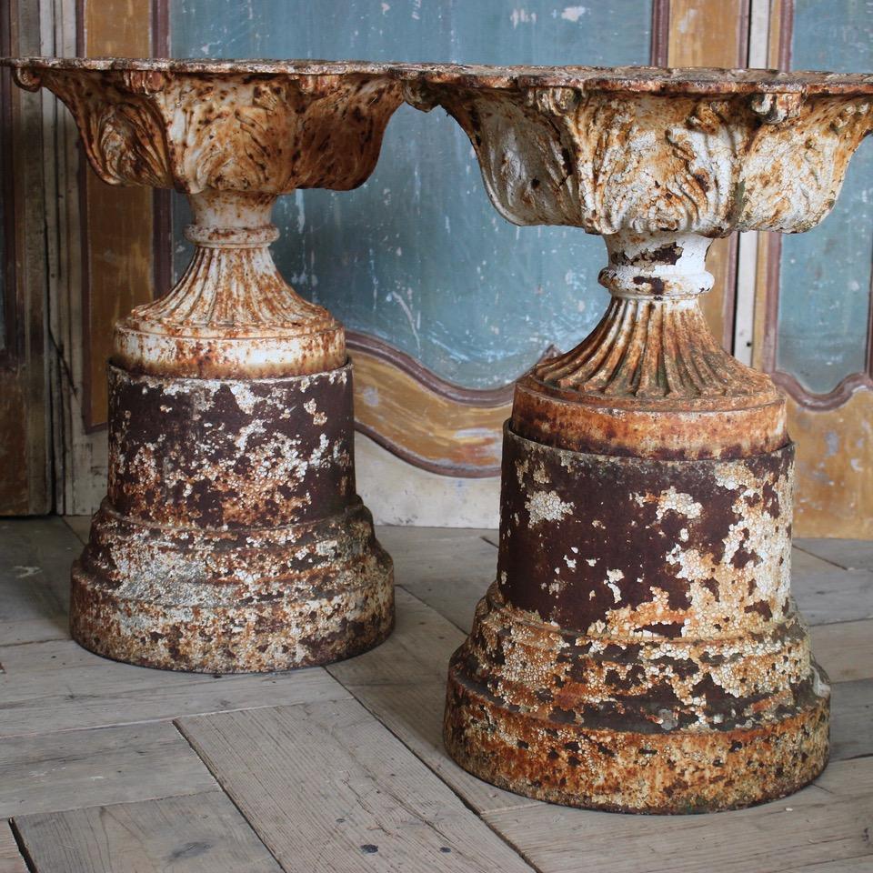 A good set of three 19th century English, cast iron garden urns retaining some of the original paint, with their original bases. 
Wonderful patina and proportions.
 