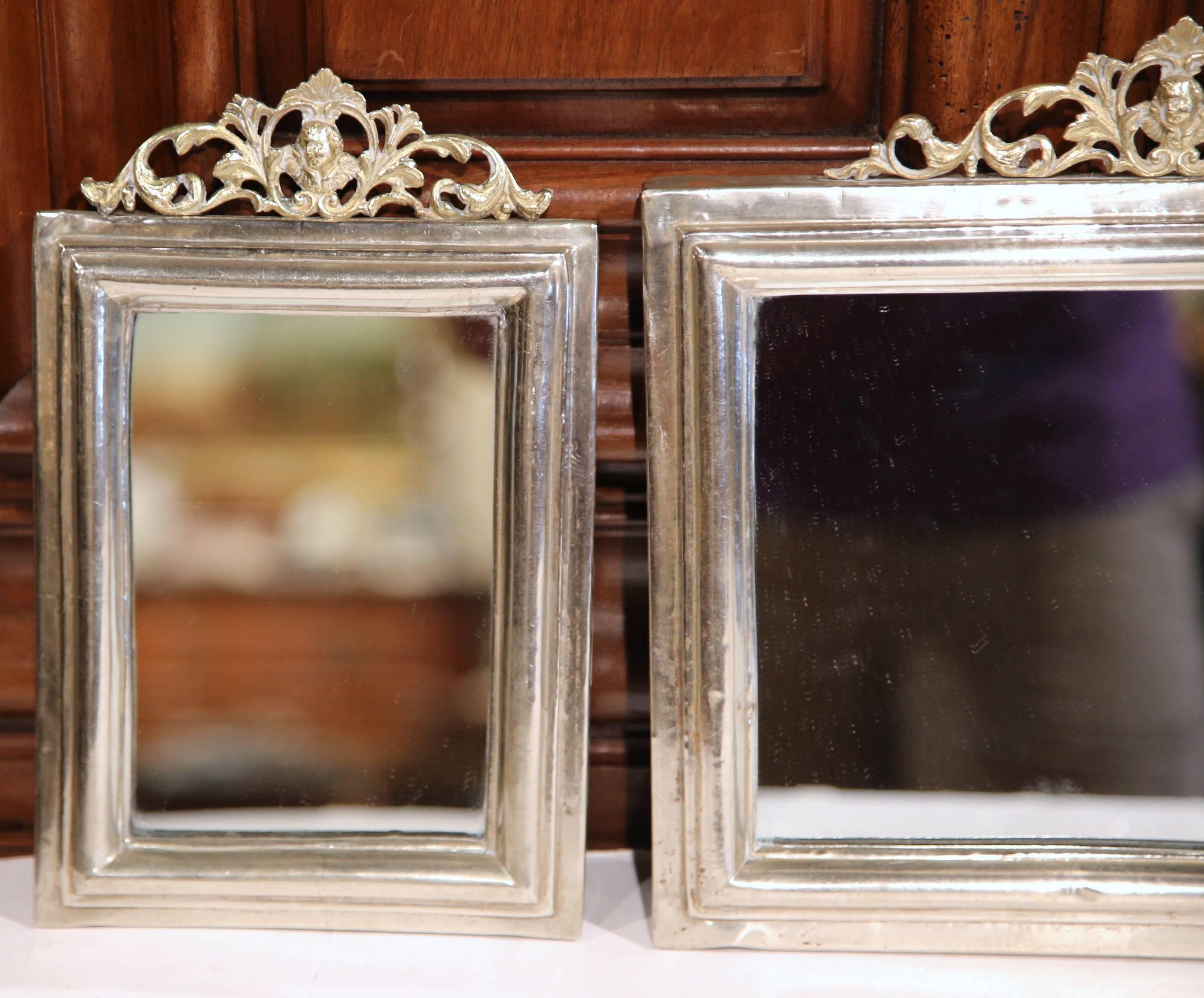 This fine, antique set of three mirrors was created in France, circa 1880. Each of the embellished, handcrafted mirrors features a intricate brass pediment with a cherub's face around a copper, silvered frame. Rectangular in shape, the mirrors are