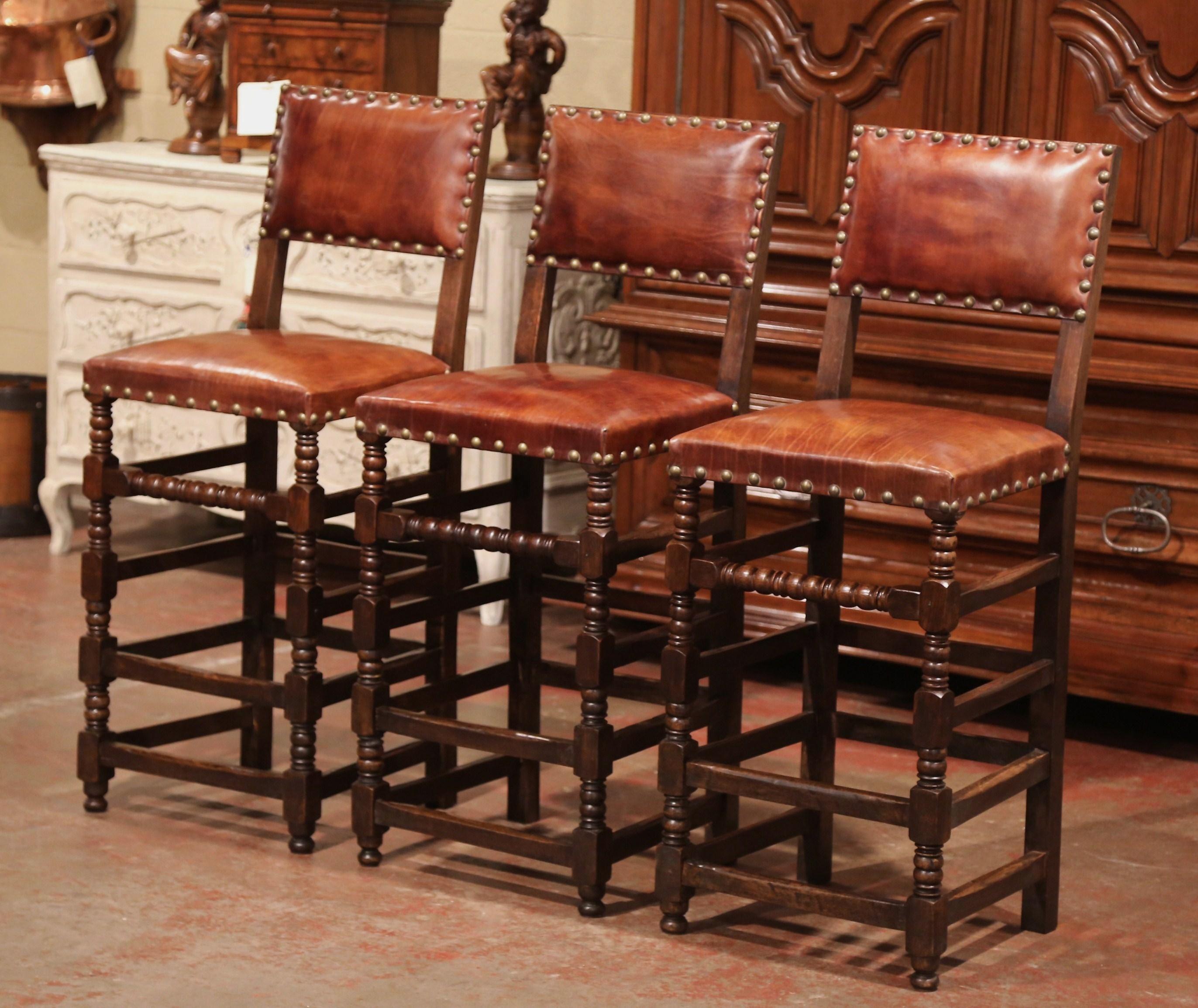 Add a Gothic look to your bar or kitchen counter with this elegant set of three antique stools. Crafted in France circa 1890, the traditional barstools are the perfect height for a 42 to 45