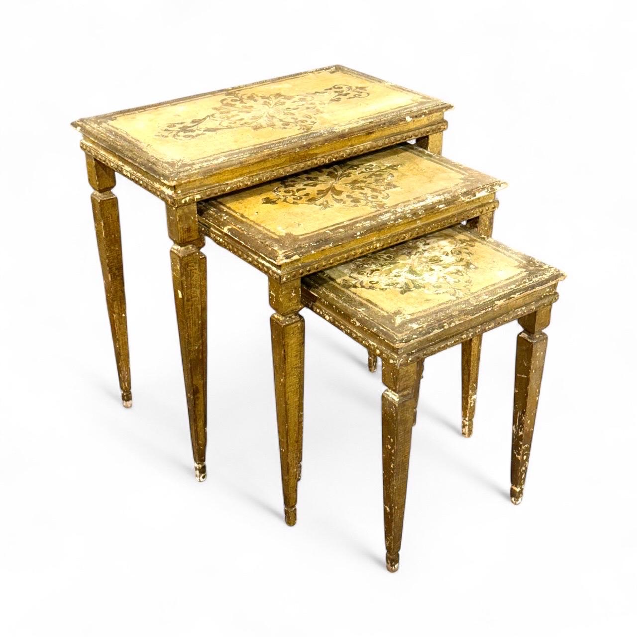 This elegant set of three Italian nesting tables dates from the 19th century and beautifully reflects the decorative traditions of the period. Crafted in giltwood, each table features tapered legs and rectangular tops adorned with hand-painted
