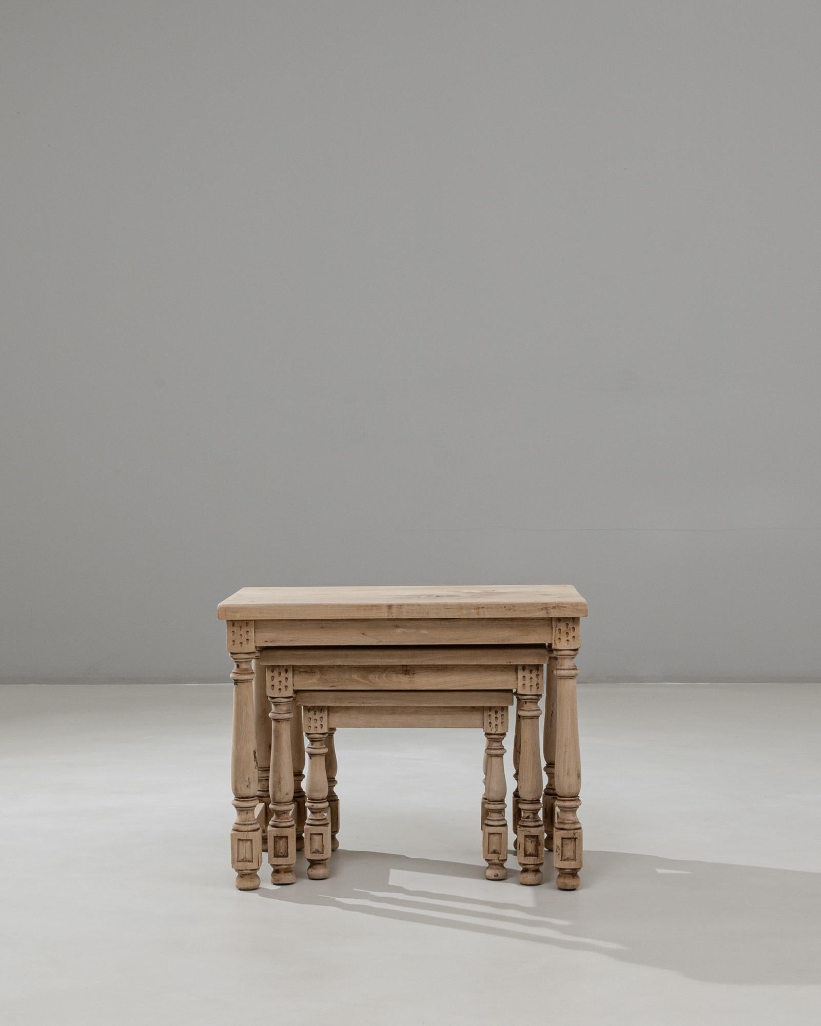Cet ensemble de trois tables gigognes en bois français du 20e siècle présente un design magnifiquement cohérent défini par des pieds tournés, des détails de blocs sculptés et une patine naturelle et chaleureuse qui met en valeur le caractère du