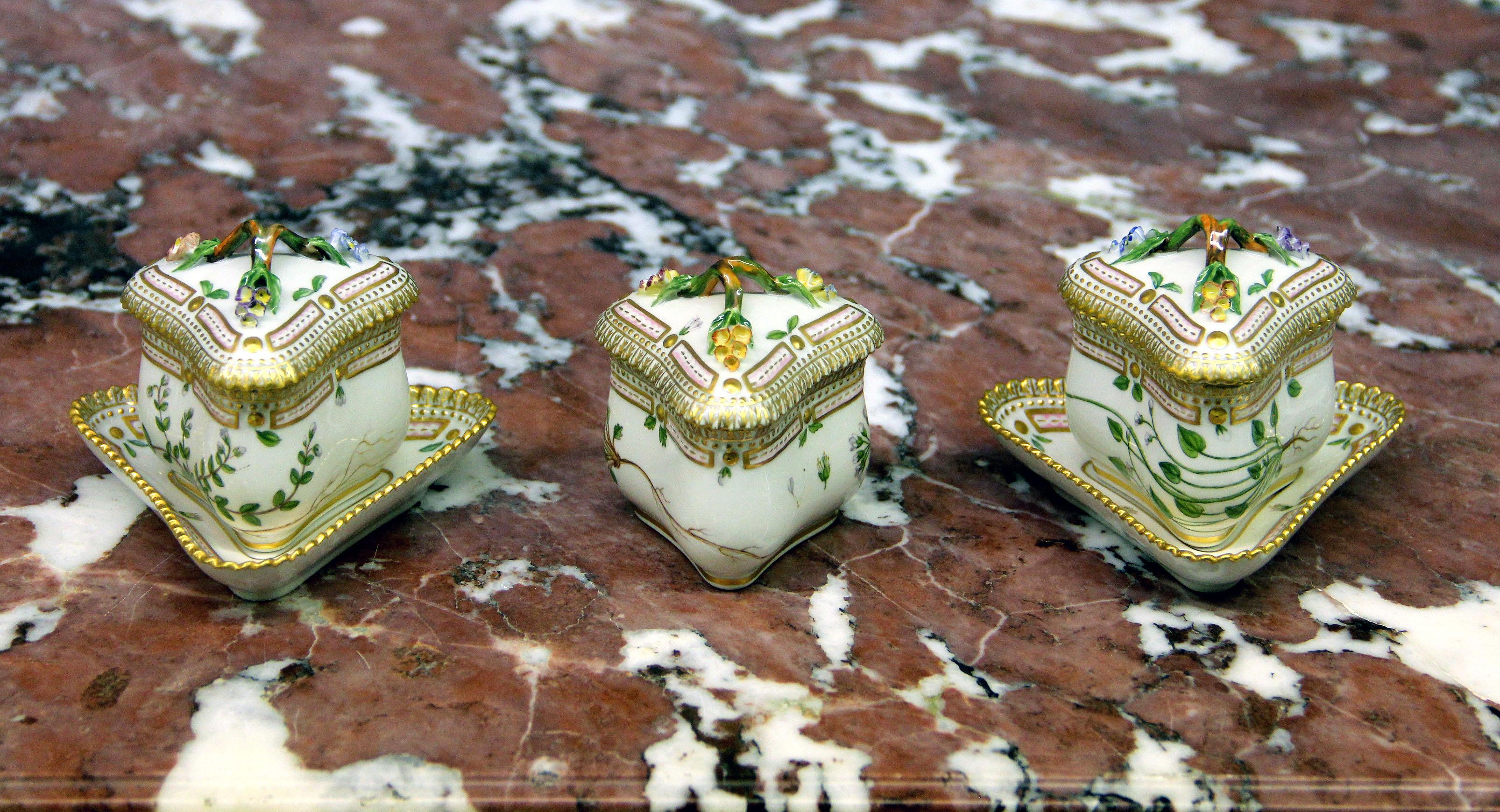 A set of three 20th century Royal Copenhagen Flora Danica Triangular Custard cups

Finely decorated with gold accent designs, reticulated rim and “A Flower From Denmark.” Stamped with Royal Copenhagen Denmark seal on the back. Three cups with two