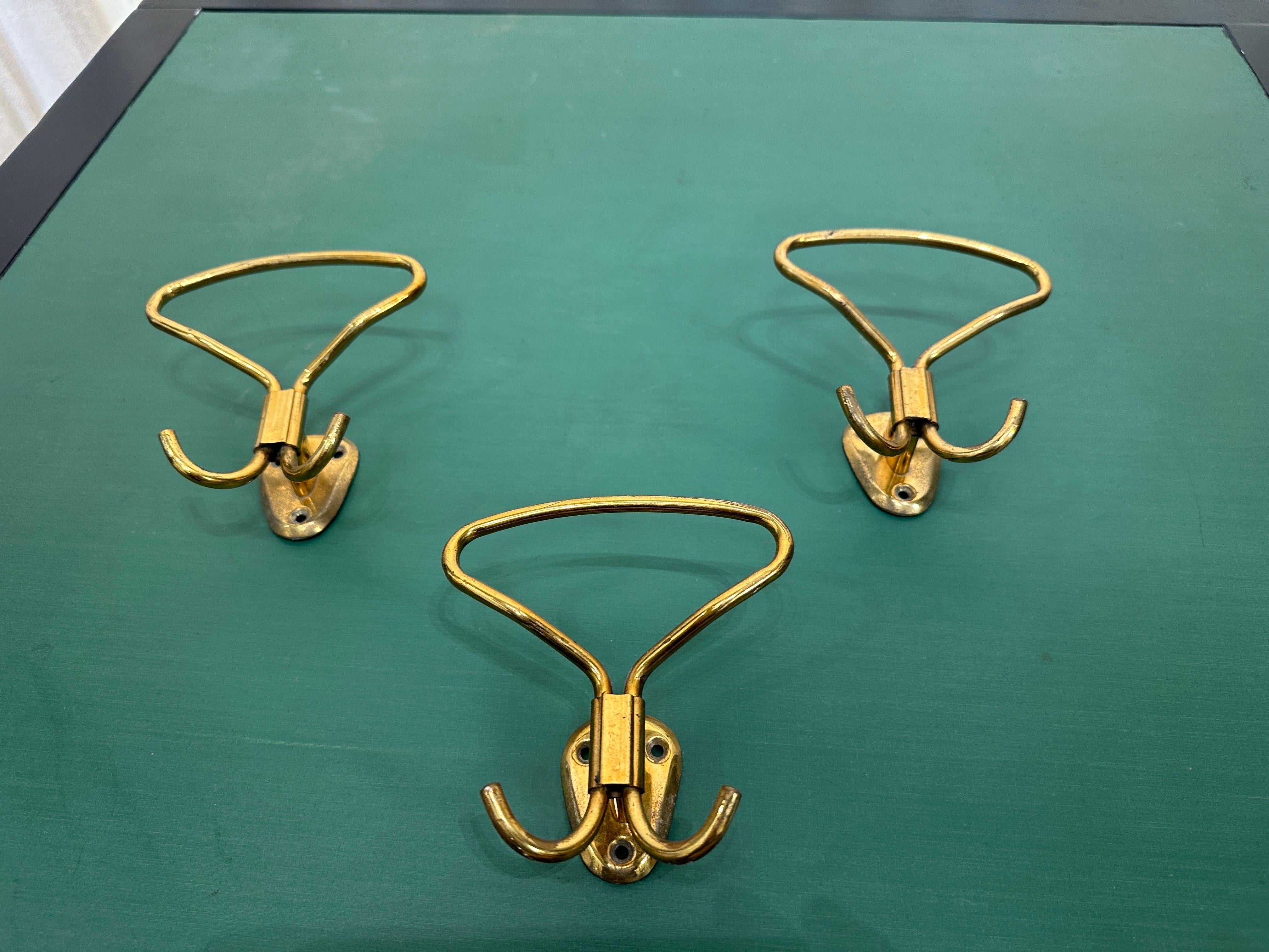 These classic mid-century design Italian wall-mounted brass hooks for coats or hats, show the simplicity yet chic Italian flare.  Perfect for any room, mud-room, foyer, bathroom, kitchen, etc.