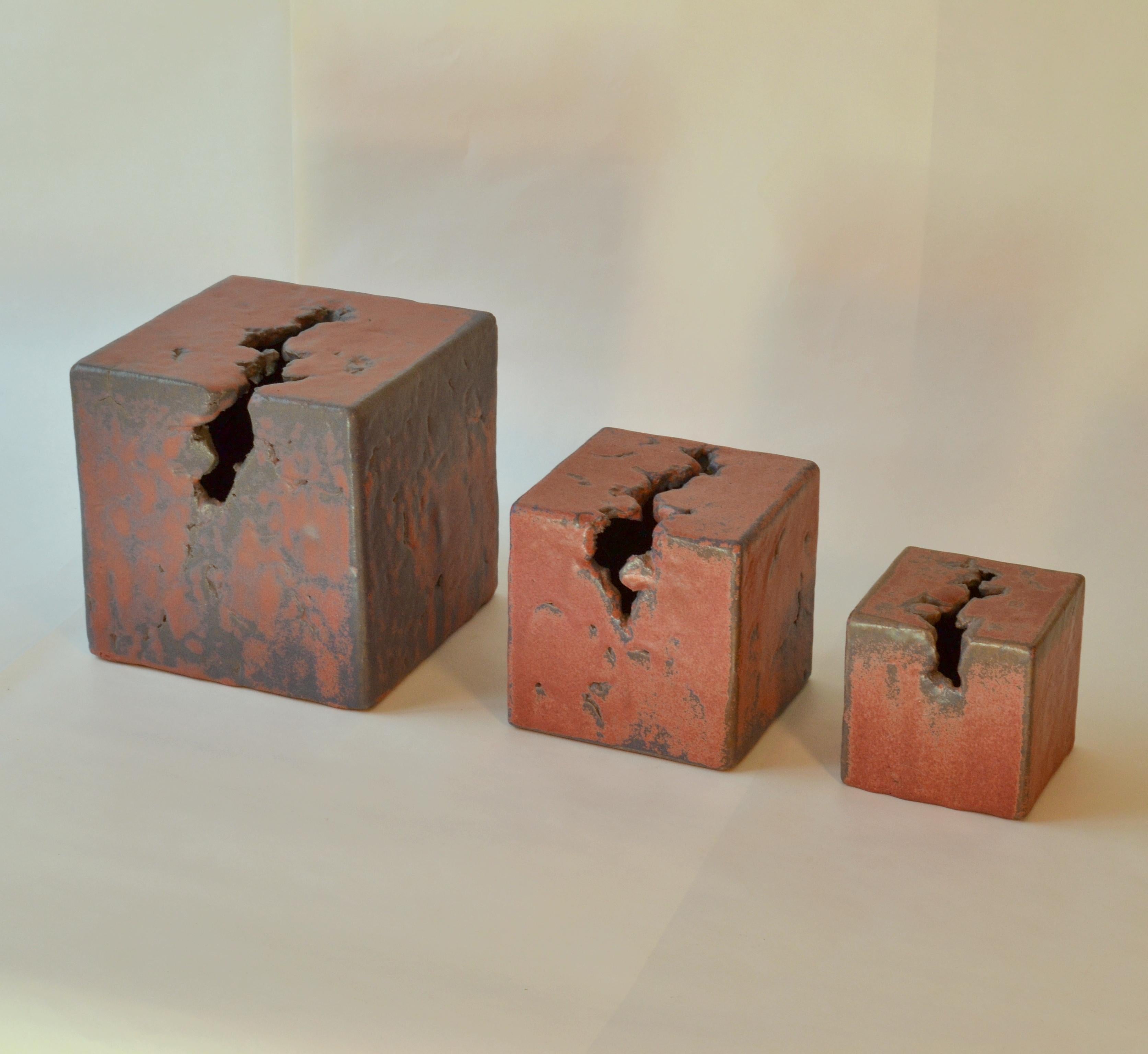 A set of three unique hand formed ceramic sculptures of cubes with crater formed openings on two planes by Mobach Studio in the Netherlands in the 1980's. Mobach ceramics are produced by the best potters in Dutch 20th century history. The mauve and