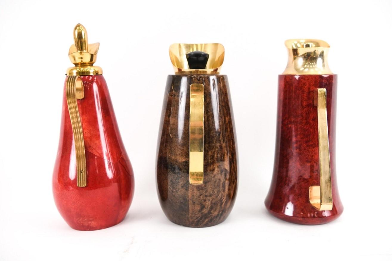 Set of three Aldo Tura Carafes. Italian, goat skin and brass carafes. All with labels underneath. 
Dimensions: Largest: H 12