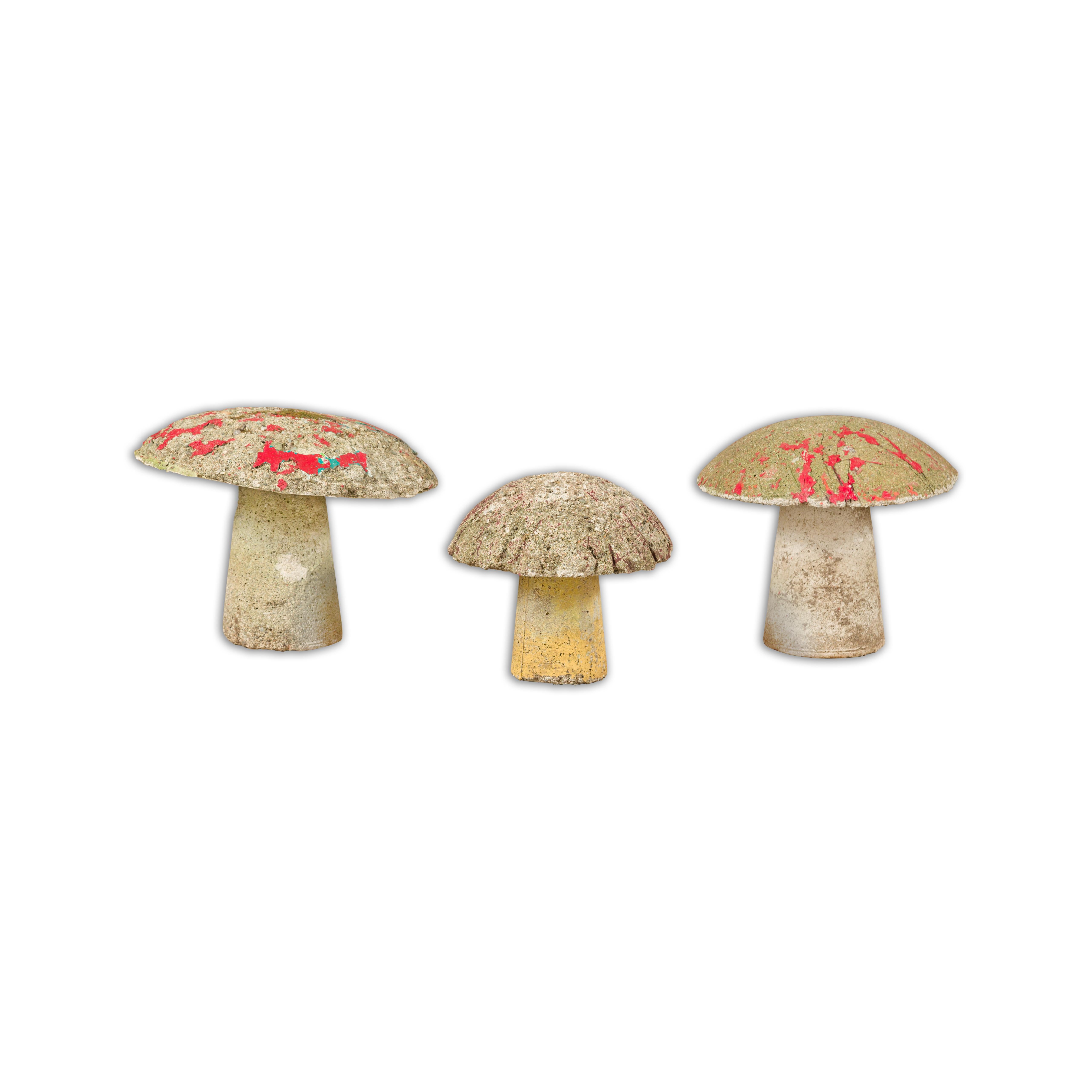 A set of three American Midcentury painted concrete mushroom garden ornaments with traces of red, turquoise and yellow paint and nicely weathered appearance. Introduce a dash of whimsy and a sprinkle of nostalgia into your garden with this set of