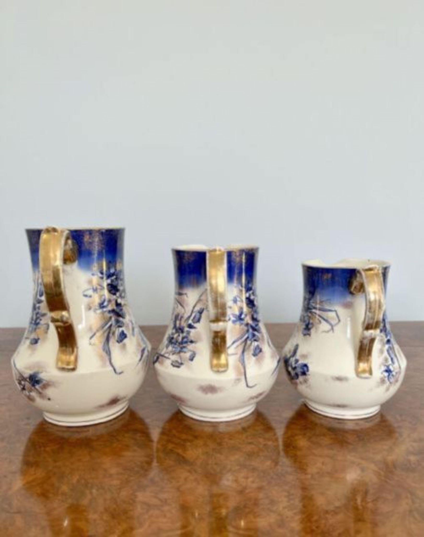 Set of three antique Edwardian jugs having shaped handles and quality hand painted decoration in blue, gold and white colours. Stamped Late Mayers 