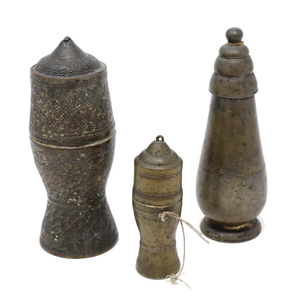 TA04027 Set of Three Antique Thai Bronze Lime Boxes. Tall Cylinders of varying shapes and sizes:
A) Thai Bronze Lime Container in the shape of a Stupa, unadorned bulbous body, gradually tapering top, terminating in a series of three steps with a