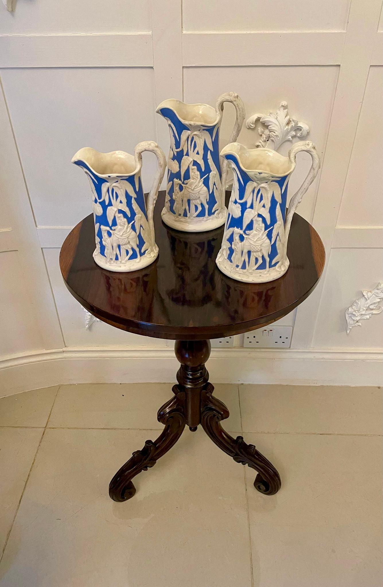 Set of three antique Victorian blue and white jugs by the prestigious Samuel Alcock having shaped tops and handles decorated with trees and gentlemen riding camels in the desert. 

Very decorative examples [minor damage as shown in