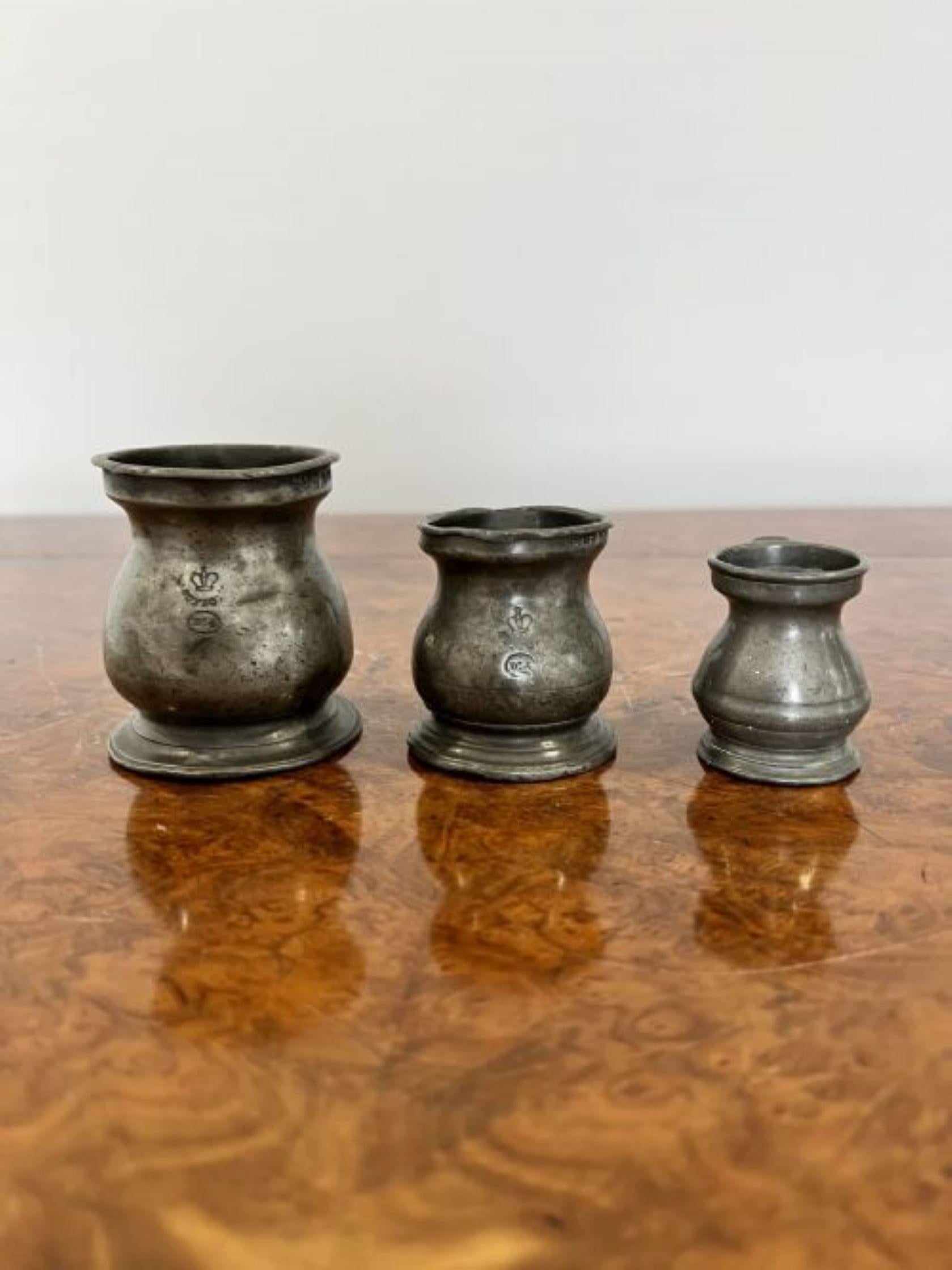 Set of three antique Victorian pewter measures marked VR, set of three antique Victorian pewter baluster measures marked VR and Suffolk to the front 

D. 1845