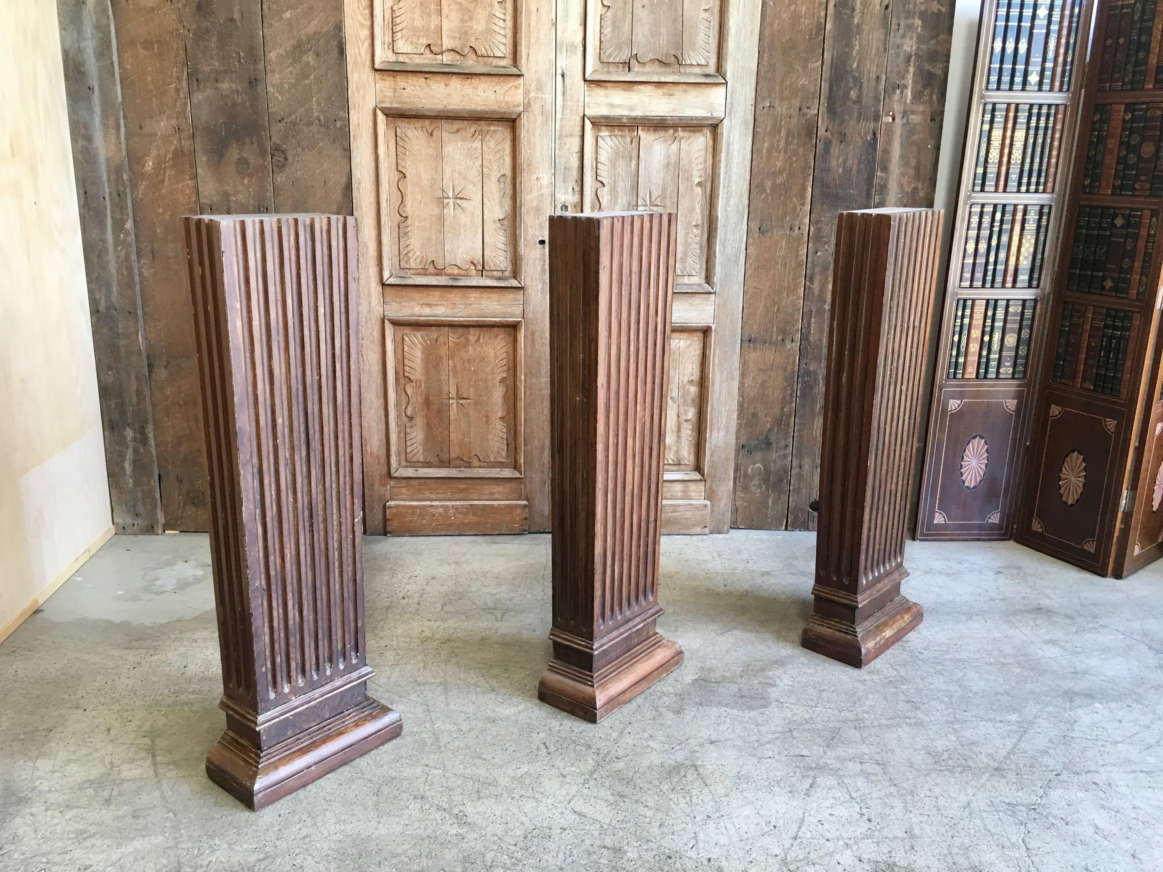 Drei Säulen aus Kiefernholz.