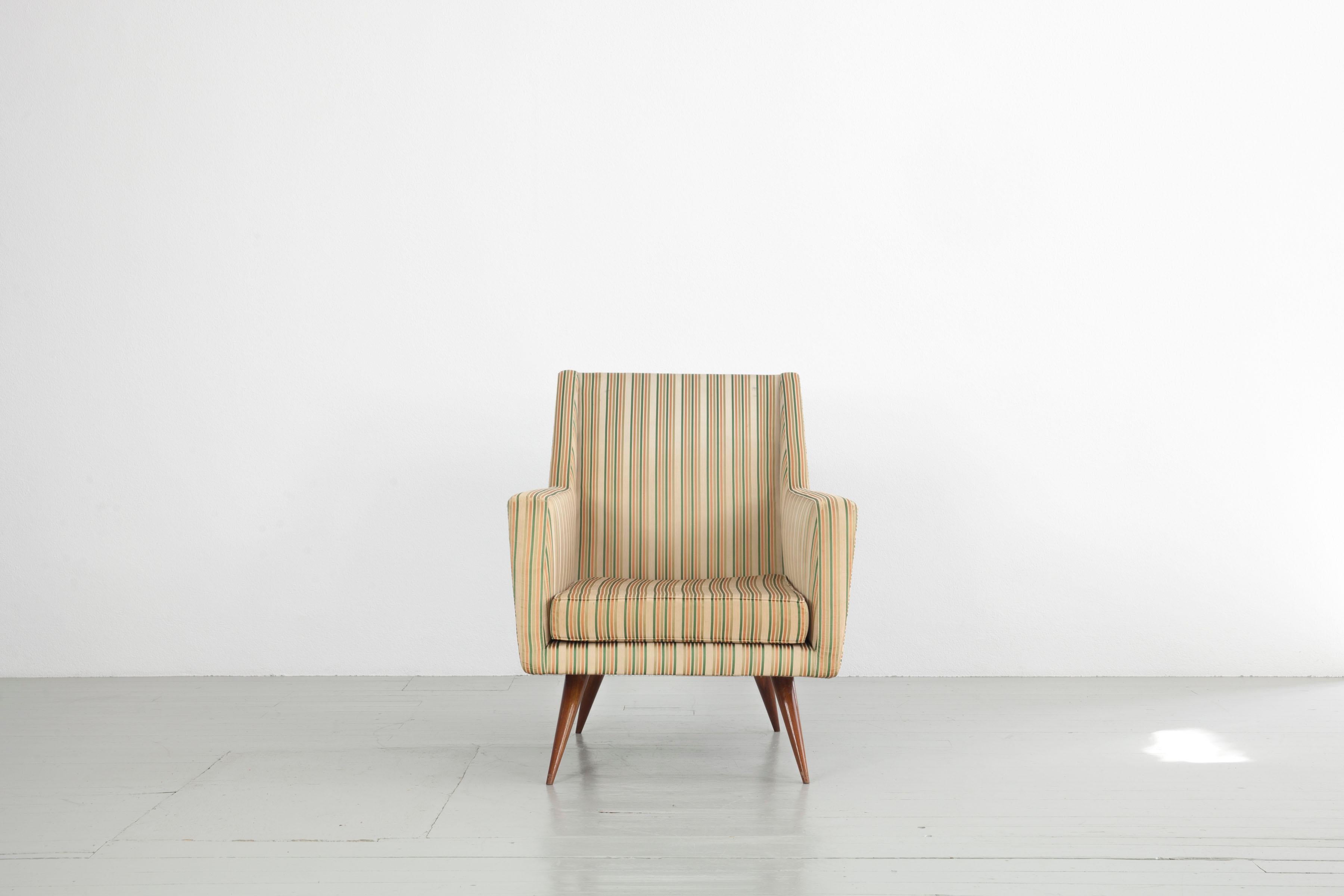 Dieser Satz von drei Sesseln wurde in den 1950er Jahren hergestellt. Der Entwurf wird Melchiorre Bega zugeschrieben. Die zweifarbigen Sessel bestehen aus konisch zulaufenden Holzbeinen, auf denen der schwere Sesselkörper mit geraden Linien ruht. Der