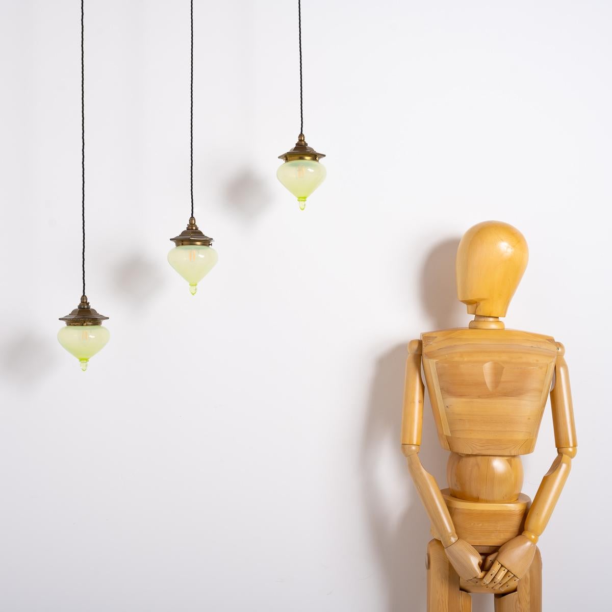 Artful Illumination: Trio of Petite Vaseline Glass Pendants

Introduce refined style with this set of three petite pendant lights. Each features a hand-crafted Vaseline glass shade in a teardrop shape, with a distinctive yellow iridescence from its