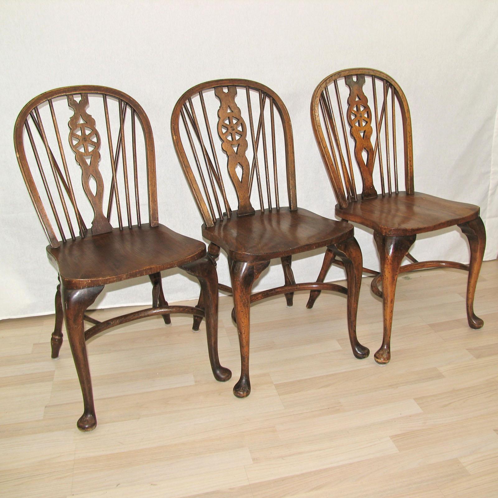 Set of 3 ash & beech wheelback Windsor chairs with cabriole leg. Backs and legs made of beech and the seats made of ash. The front legs are of cabriole design, back legs turned, supported with a crinoline stretcher. Original label under the seat