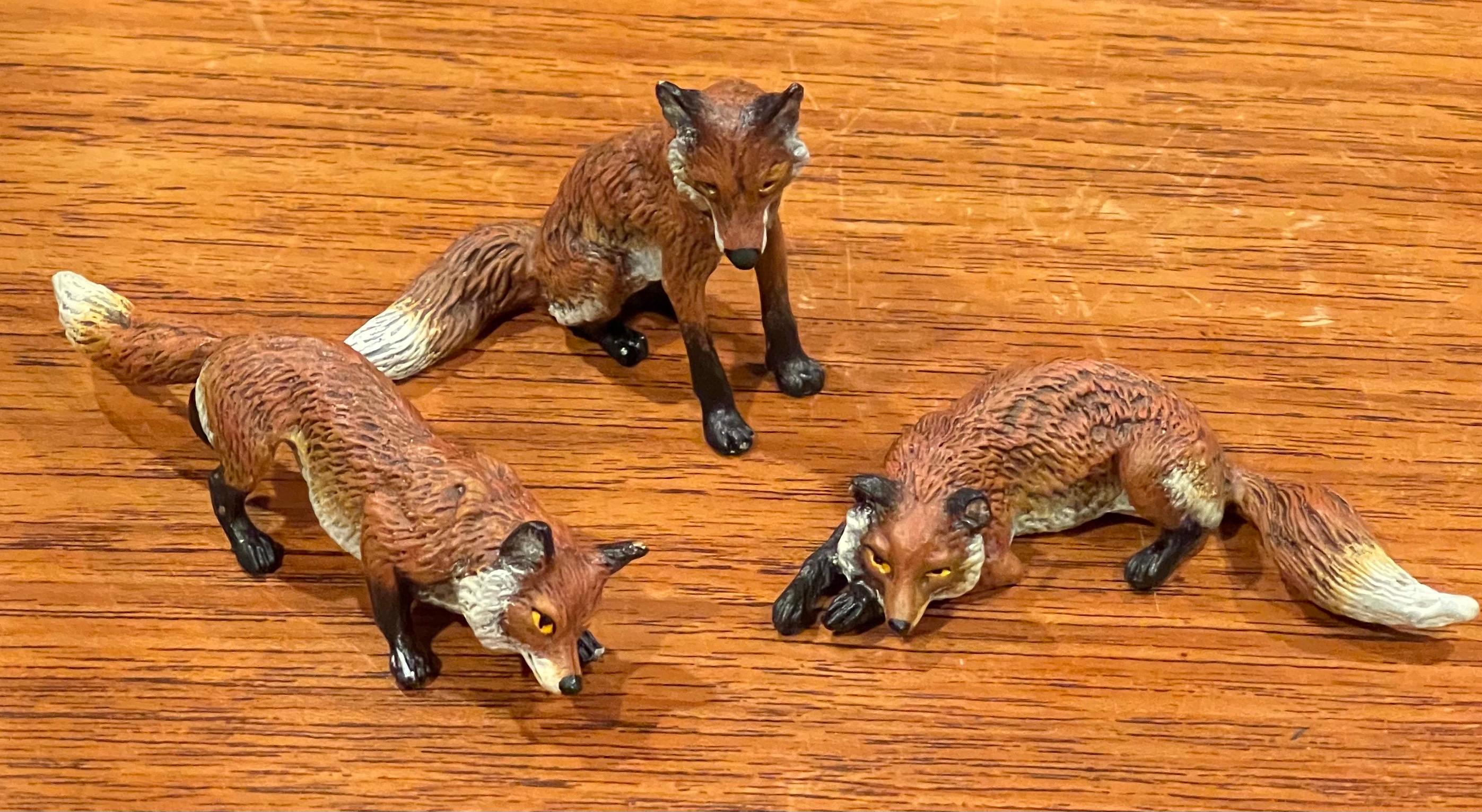 Set of three Austrian bronze hand painted miniature fox sculptures, circa 2000s. These pieces have amazing detail and weight and are in excellent condition. Each piece is individually cast from sand molds that are used only once, then sculpted and