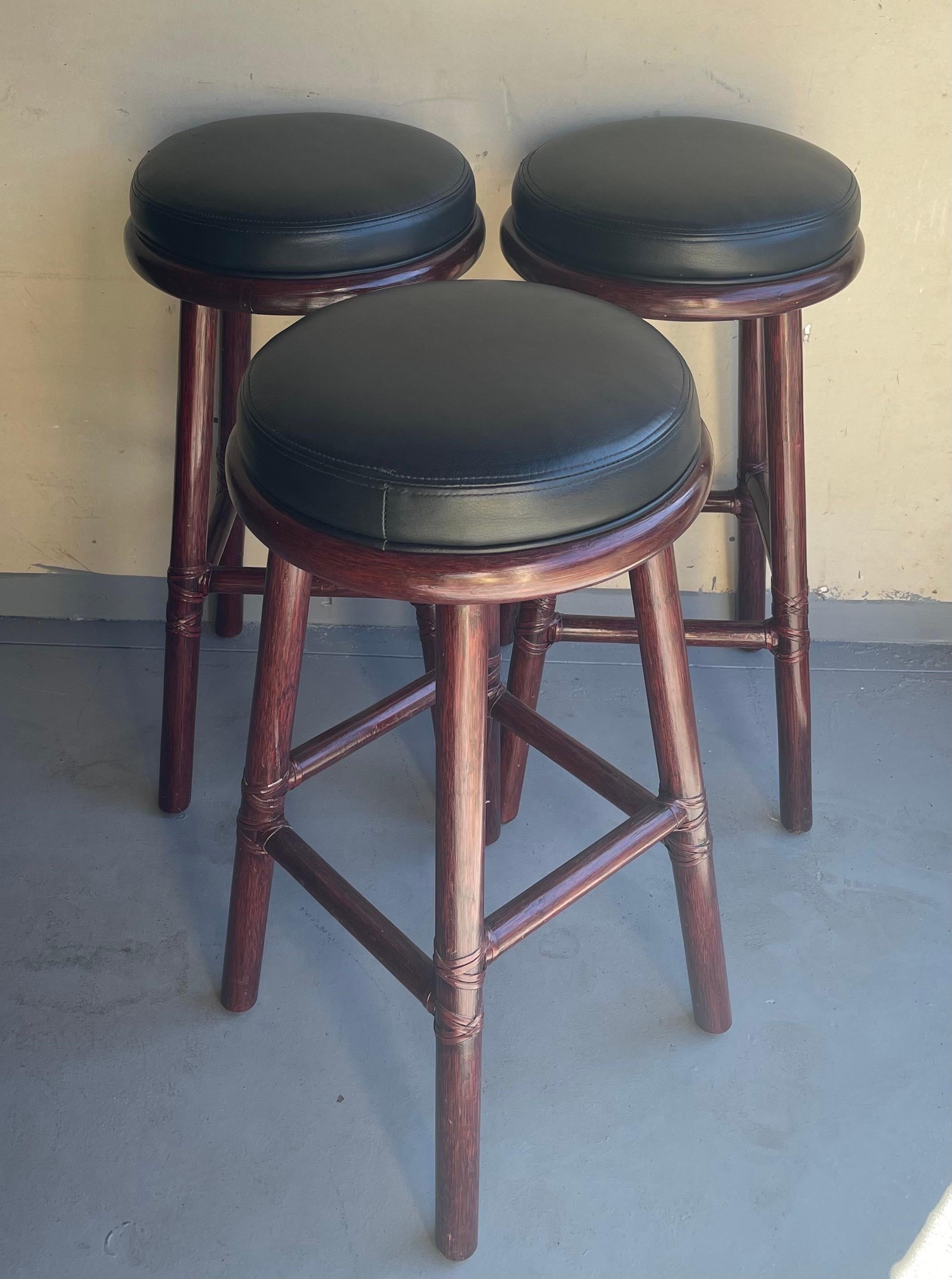 20ième siècle Ensemble de trois tabourets de bar en bambou et cuir de McGuire Furniture Co. en vente