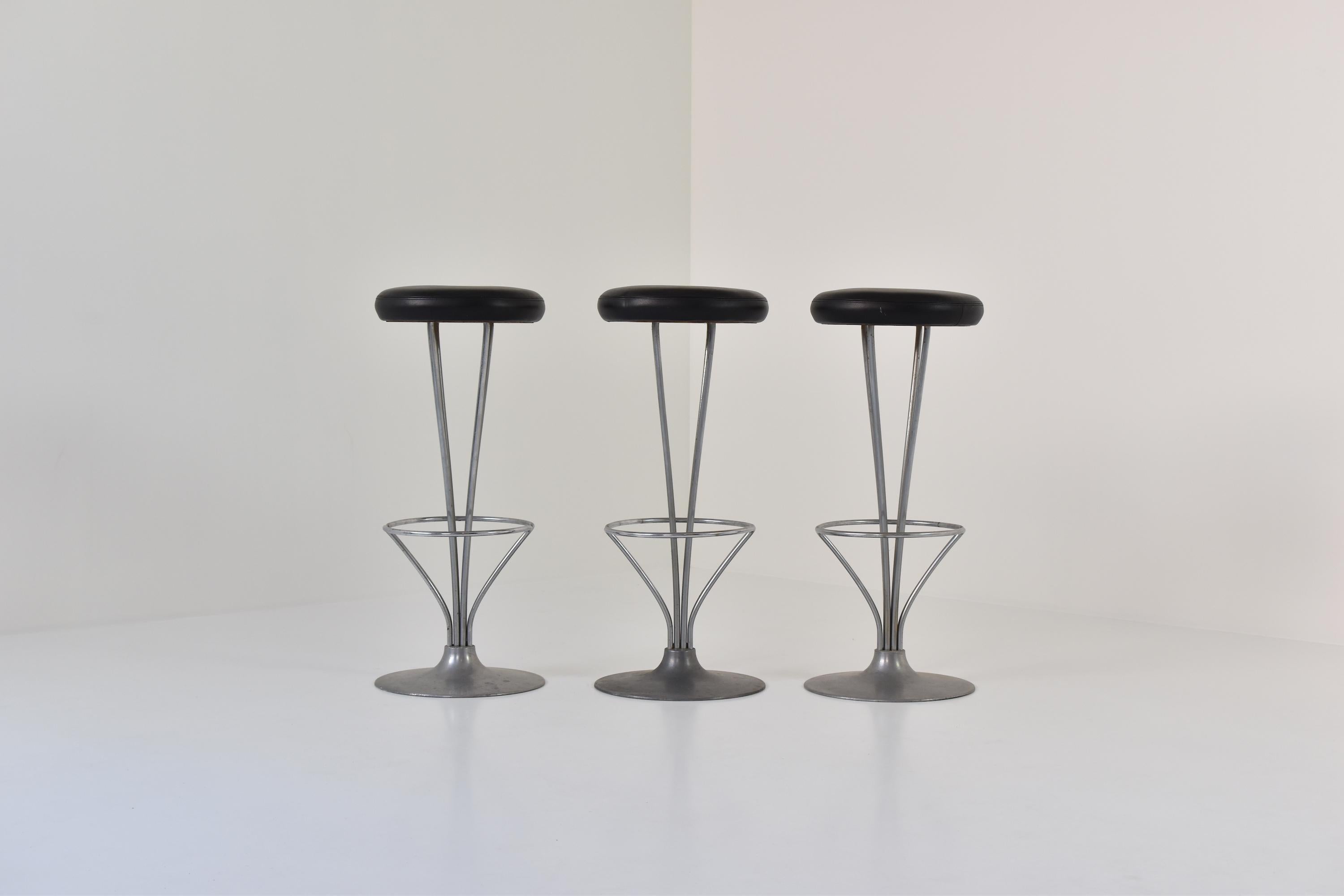 Lovely set of three bar stools by Piet Hein for Fritz Hansen, Denmark, 1960s. These stools have chrome-plated frames and a brushed aluminum base with the original black leather upholstery. One of the best modern bar stool designs of the 20th