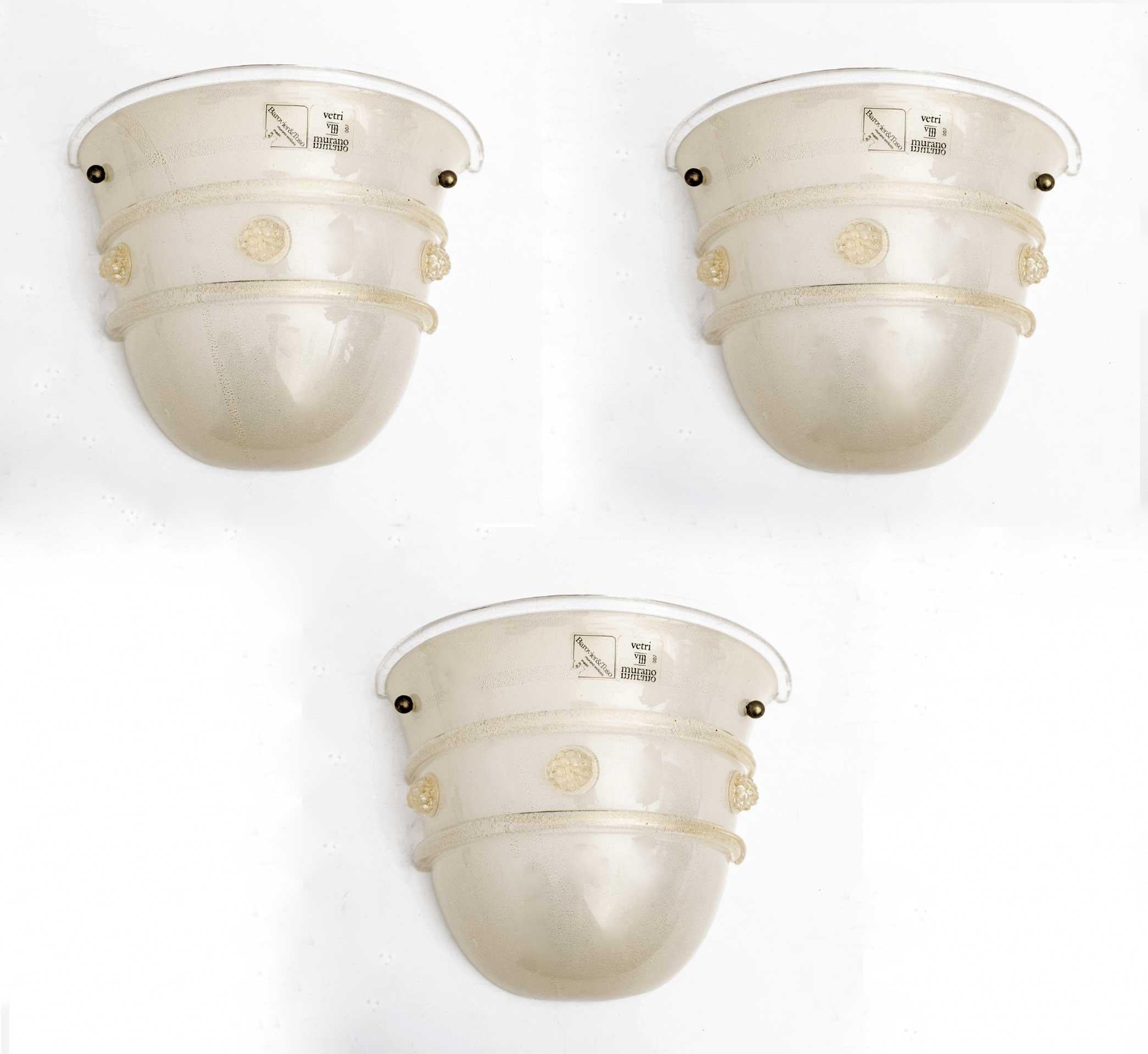 Ensemble de trois appliques en verre de Murano soufflé à la main, de style Mid-Century Modern, produit par Barovier&Toso dans les années 1980. Avec des détails en forme de fleurs. Le verre est rempli de bulles et de mouchetures dorées qui lui