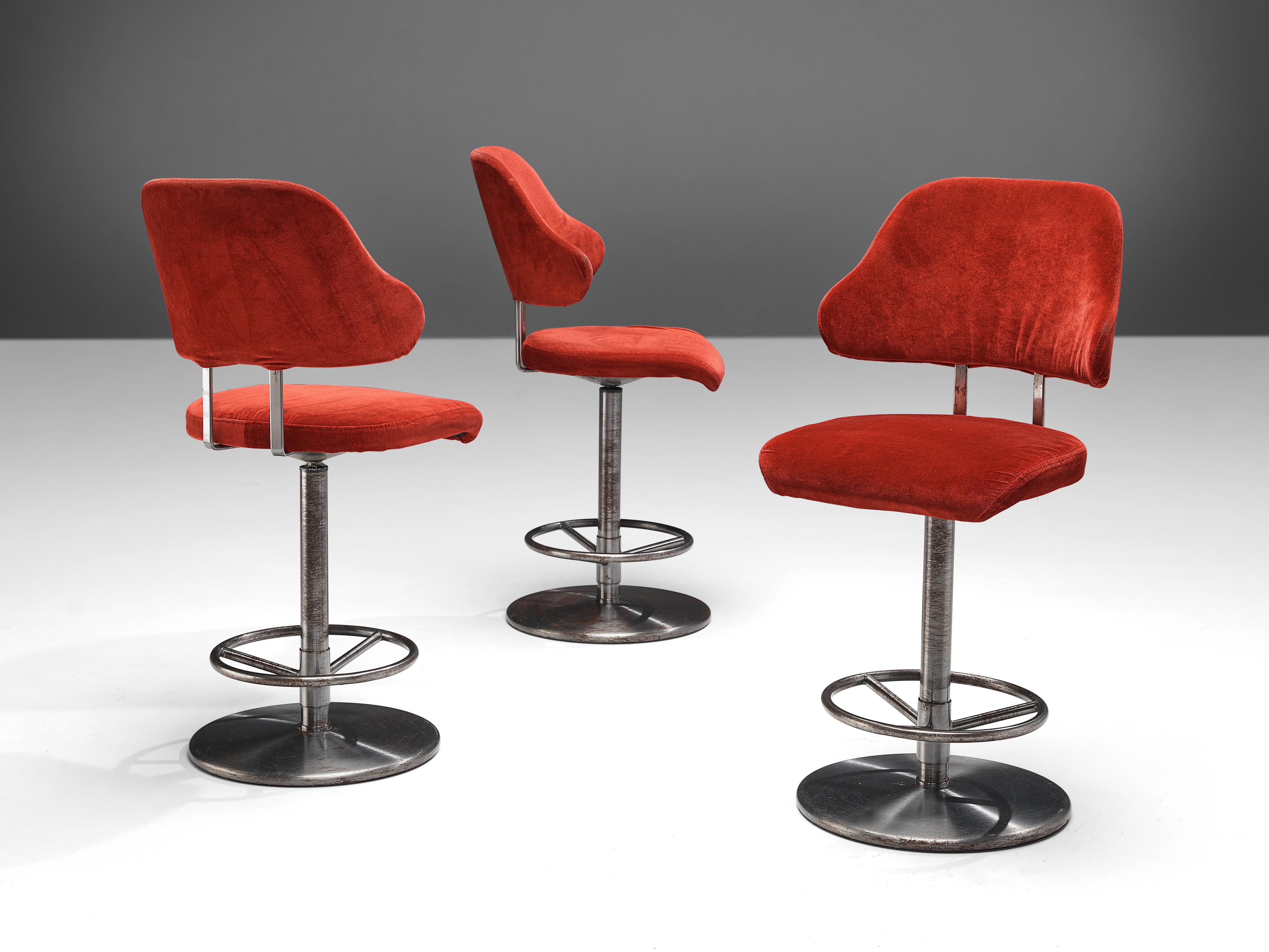 Barstools, metal, upholstery, Europe, 1970s

This set of barstools is currently upholstered in eye-catching red velvet. A comfortable seat and curved backrest have an inviting look. The round base includes a footrest.

Please note that we advise