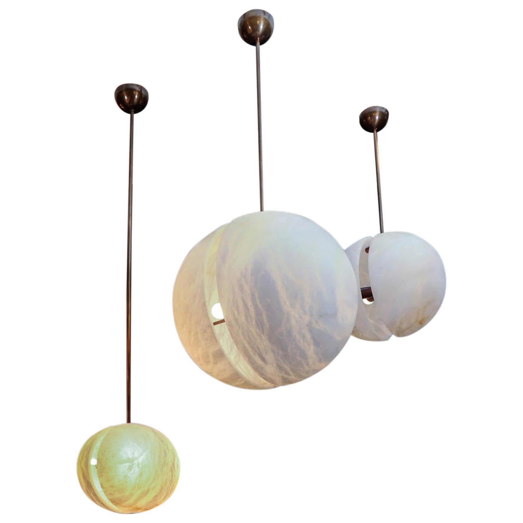Ensemble de trois suspensions en laiton et en albâtre en forme de demi-sphères par Glustin Luminaires