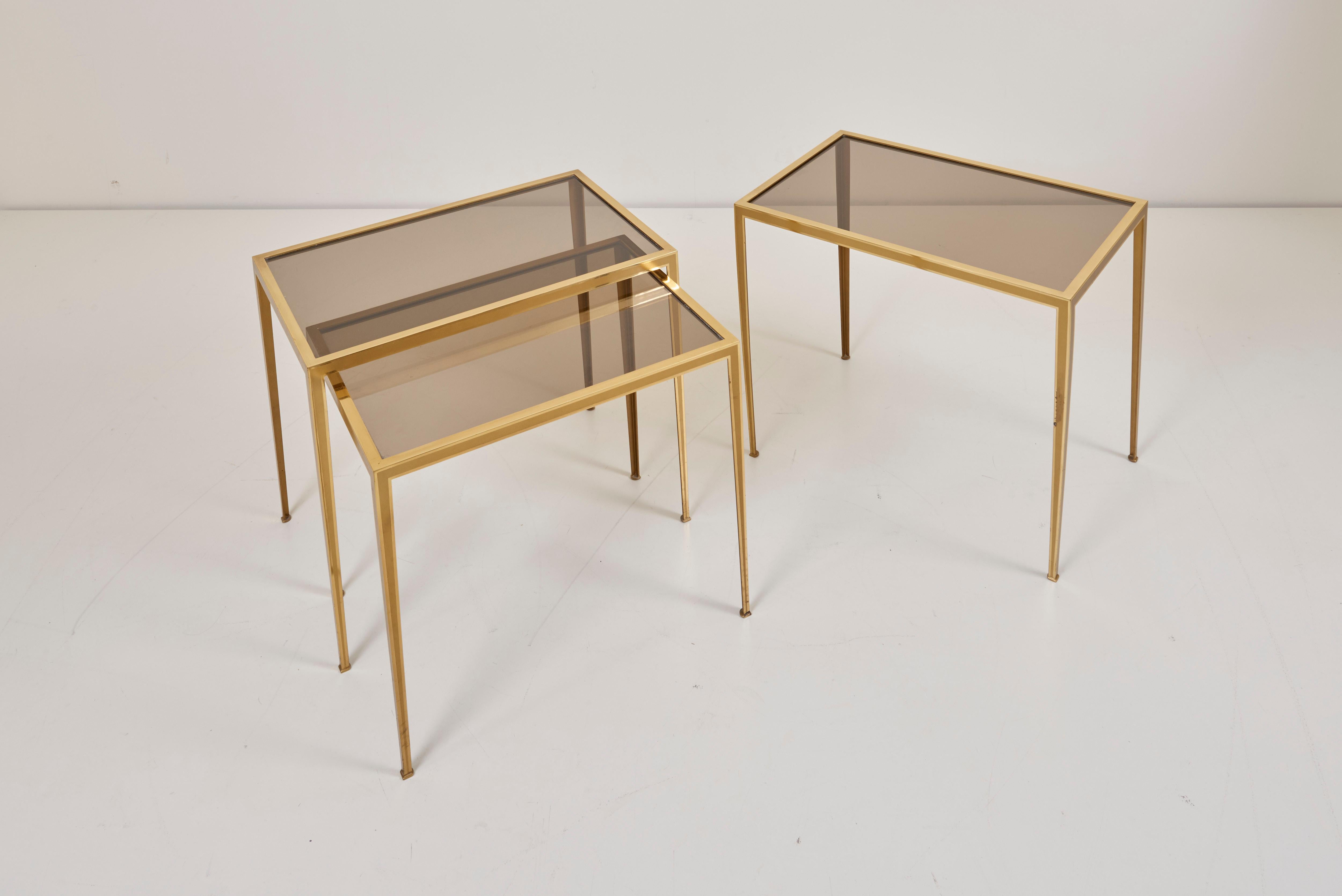 Wonderful set of three brass nesting tables with glass tops in very good vintage condition. The table legs in tapering shape providing elegance and lightness to the tables.

Measurements show the both bigger tables.
Measurements of the small