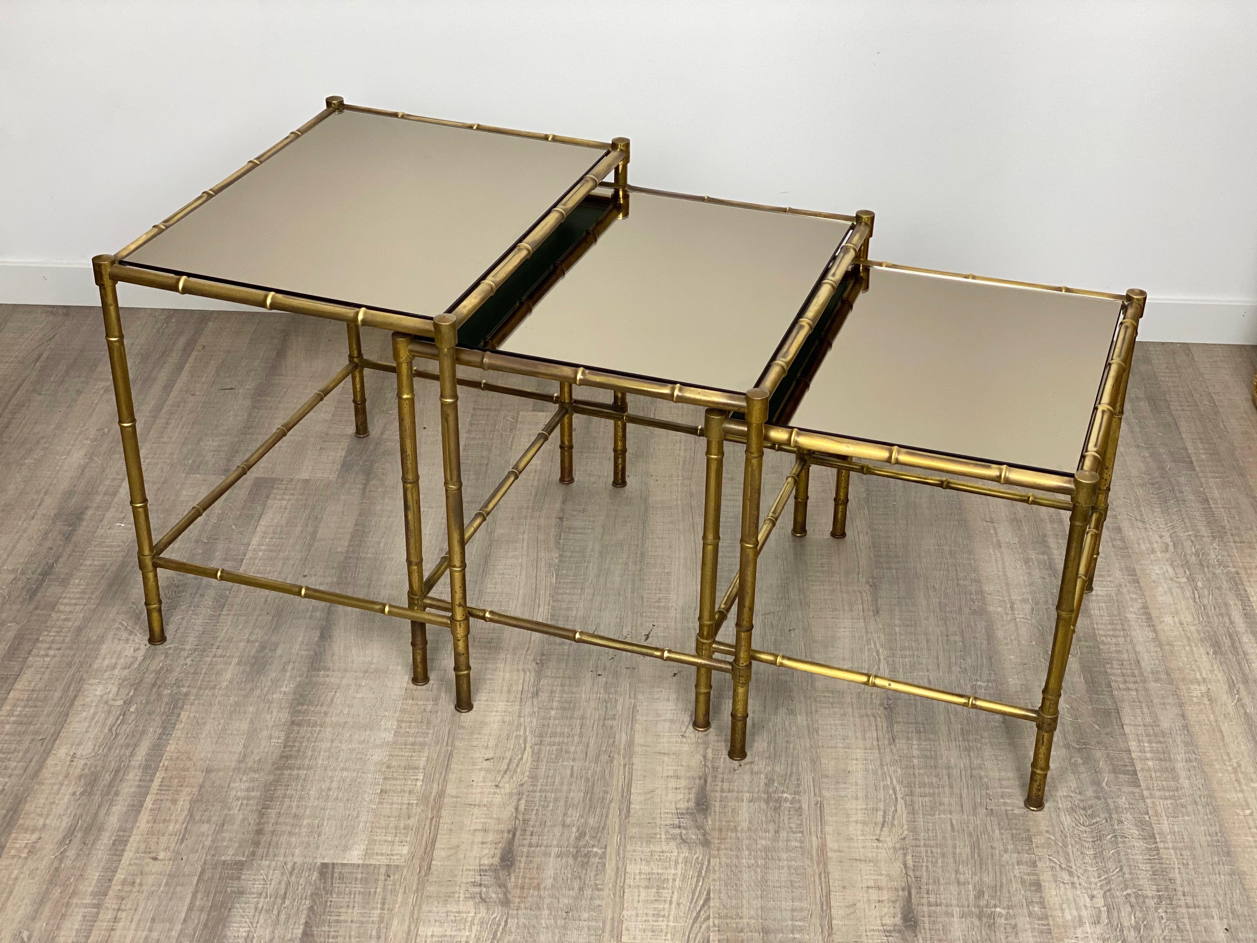 These Classic and elegant solid brass nesting coffee tables are made of mirror surfaces and faux bamboo brass structures by Maison Baguès,
France, circa 1960.

           