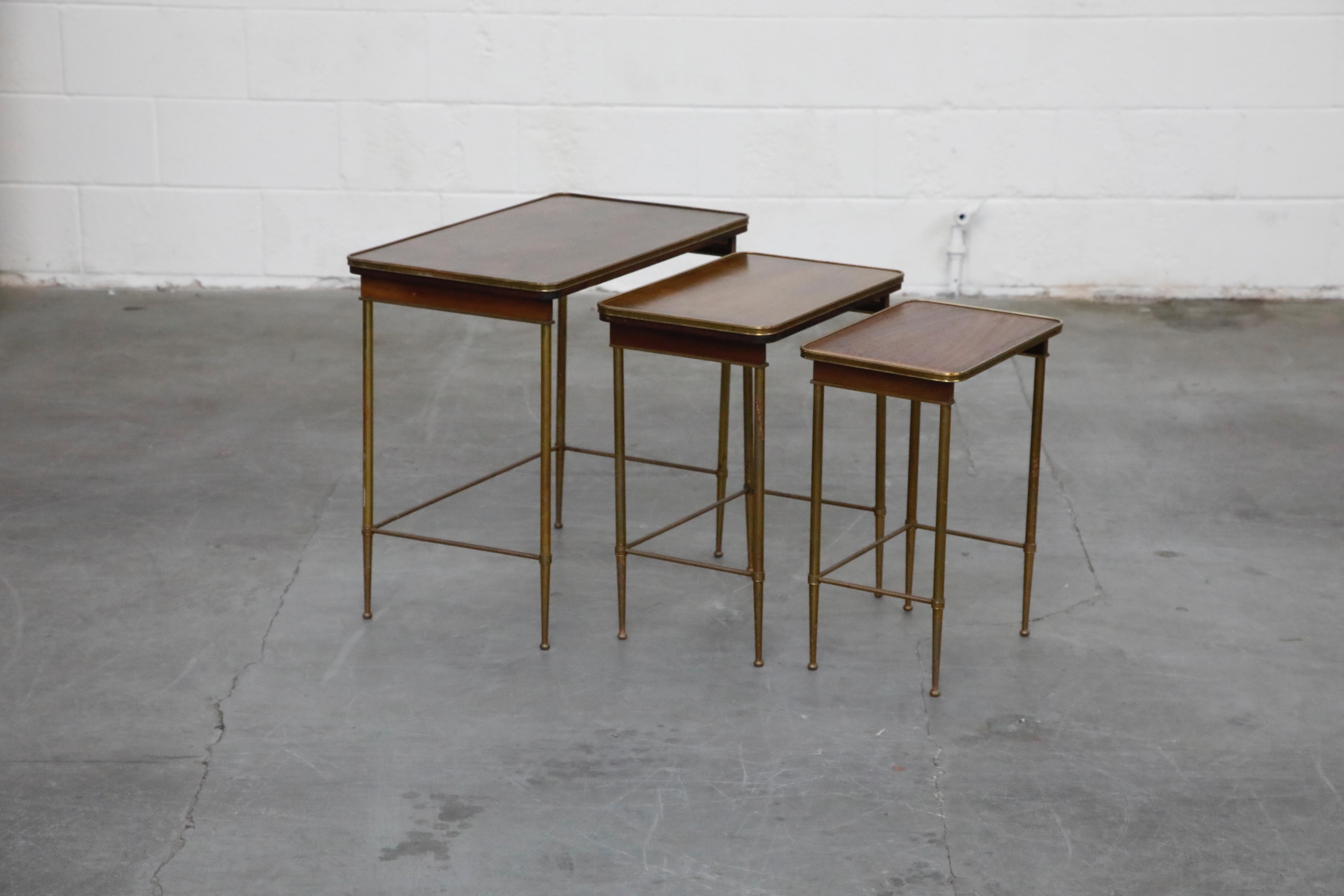 An attractive set of three (3) Mid-Century Modern nesting tables. This set of nesting tables is in its original beautiful finish with light, attractive patina throughout. Would look excellent in almost any style of decor, including Hollywood