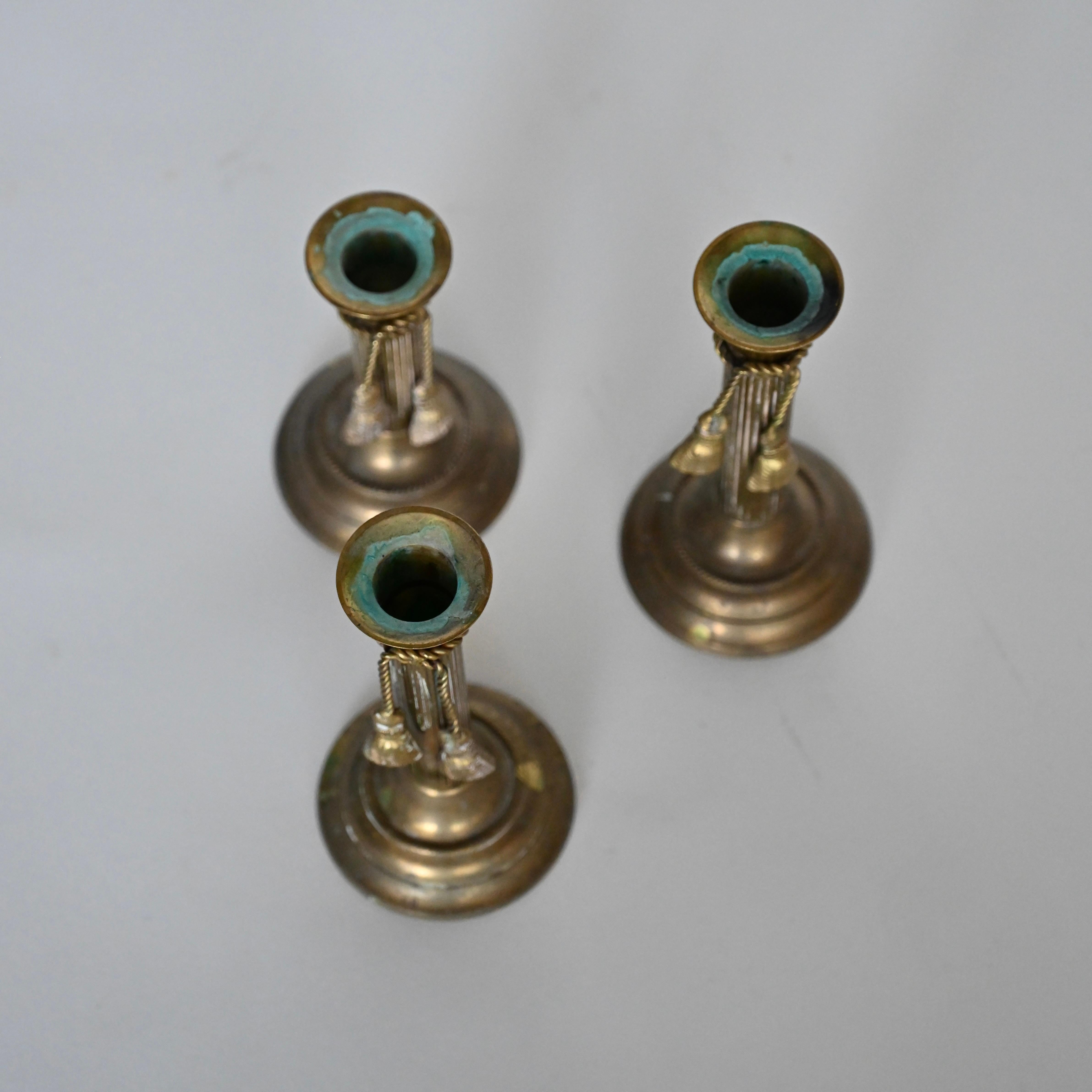 Set of three brass candlesticks with tassel detail, mid 20th century. In Good Condition For Sale In Venice, CA