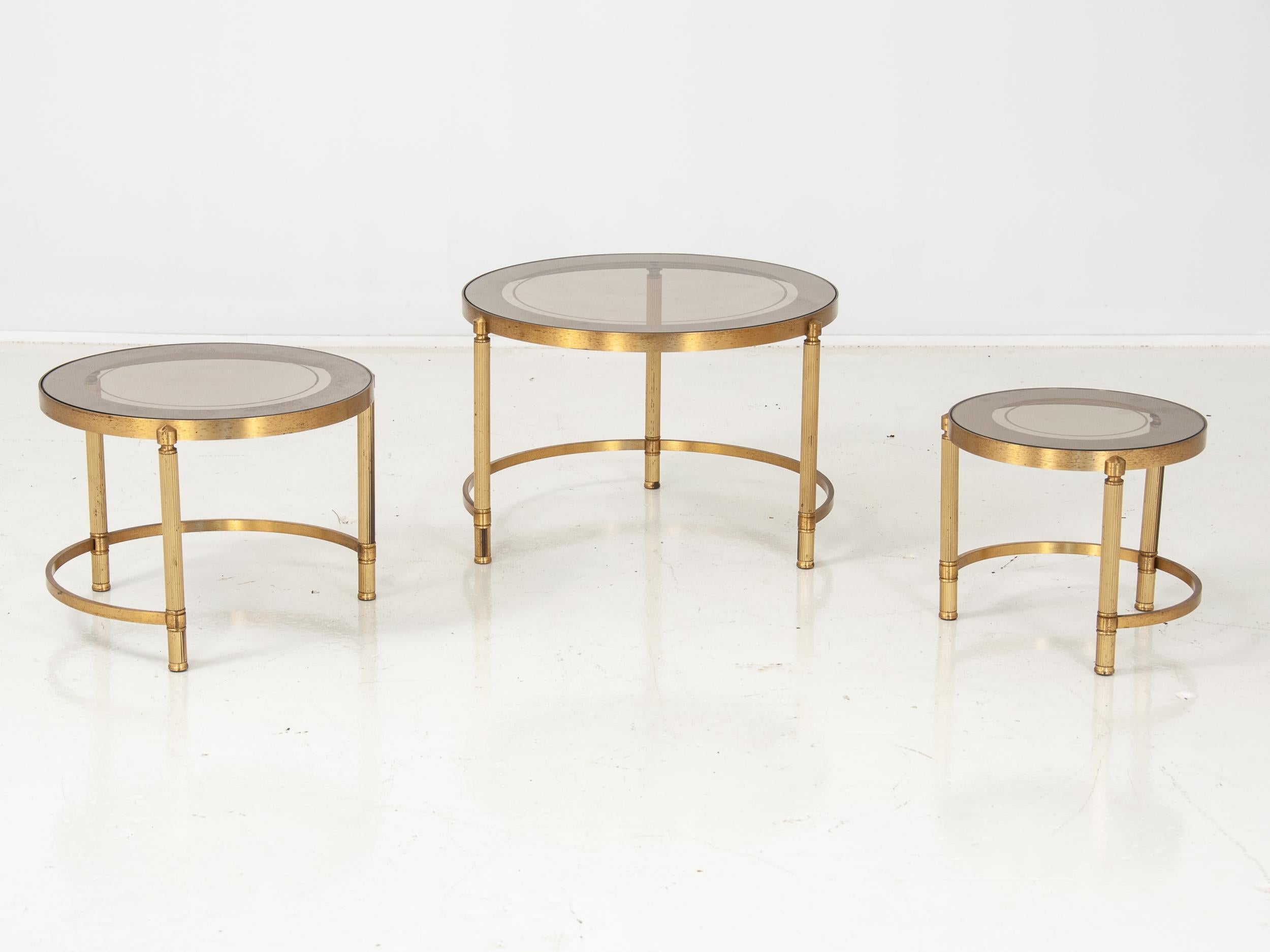 Fantastic set of nesting tables with brass bases and fluted legs, two-toned drop-in glass tops. Art Deco style.