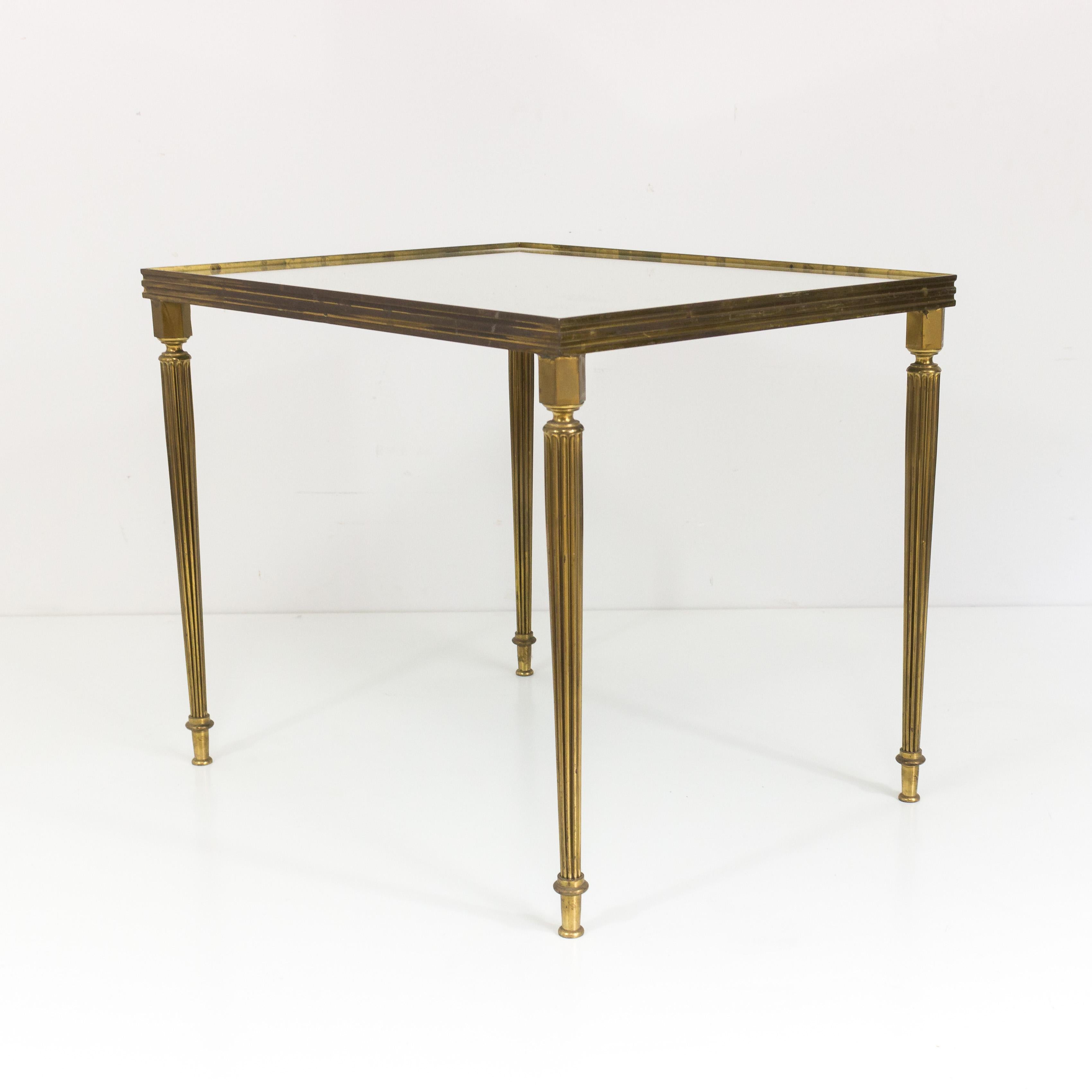 Set of three nesting tables with fluted brass legs and brass frames and mirrored tops, French, 1940s.

This item is currently in France, please allow 2 to 4 weeks delivery to New York. Shipping costs from France to our warehouse in New York