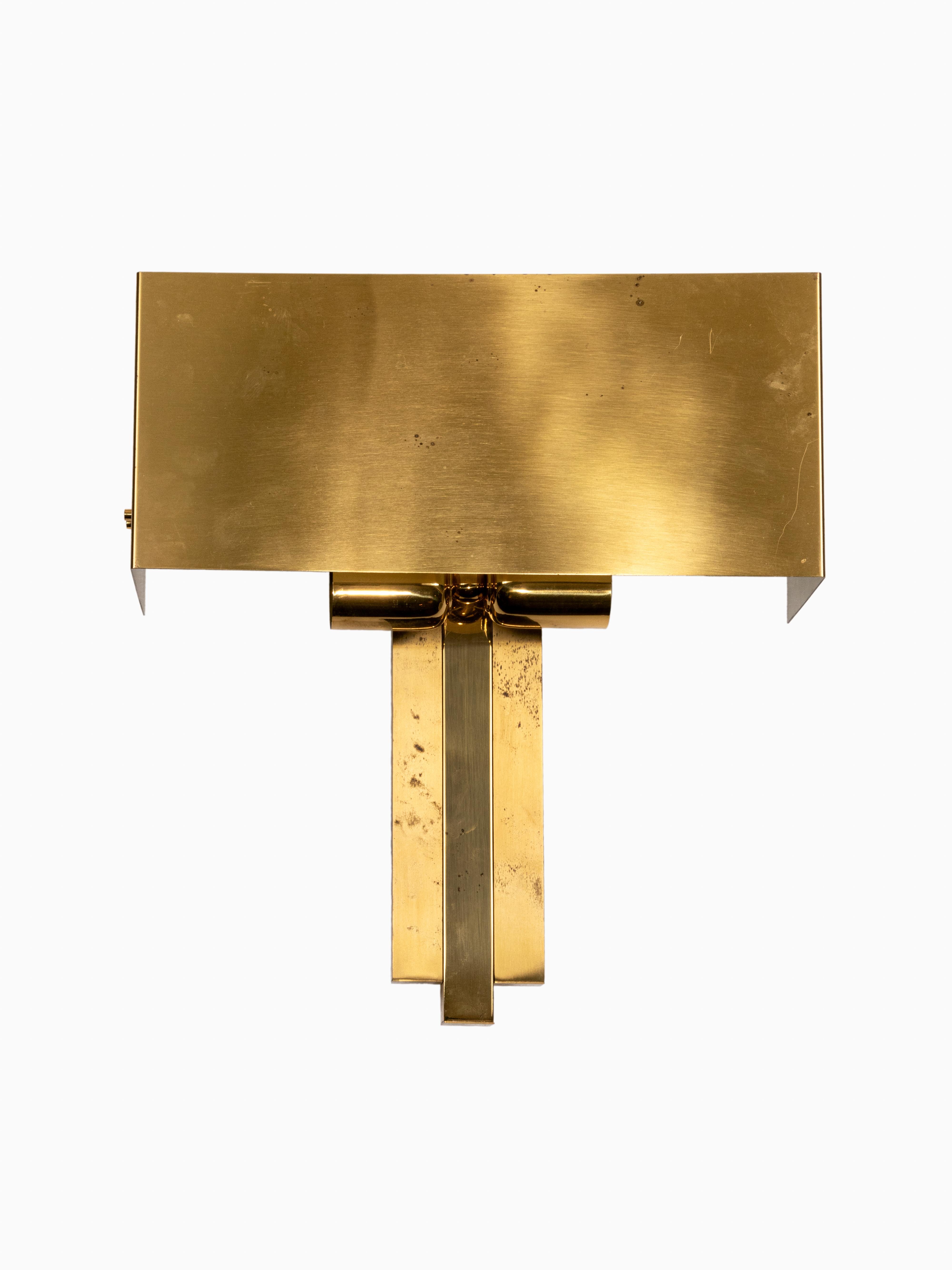 Un elegante y moderno conjunto de tres apliques de pared diseñado por el famoso fabricante alemán WKR Leuchten, que data de hacia 1970. Cada aplique tiene una exclusiva pantalla de latón en forma de 