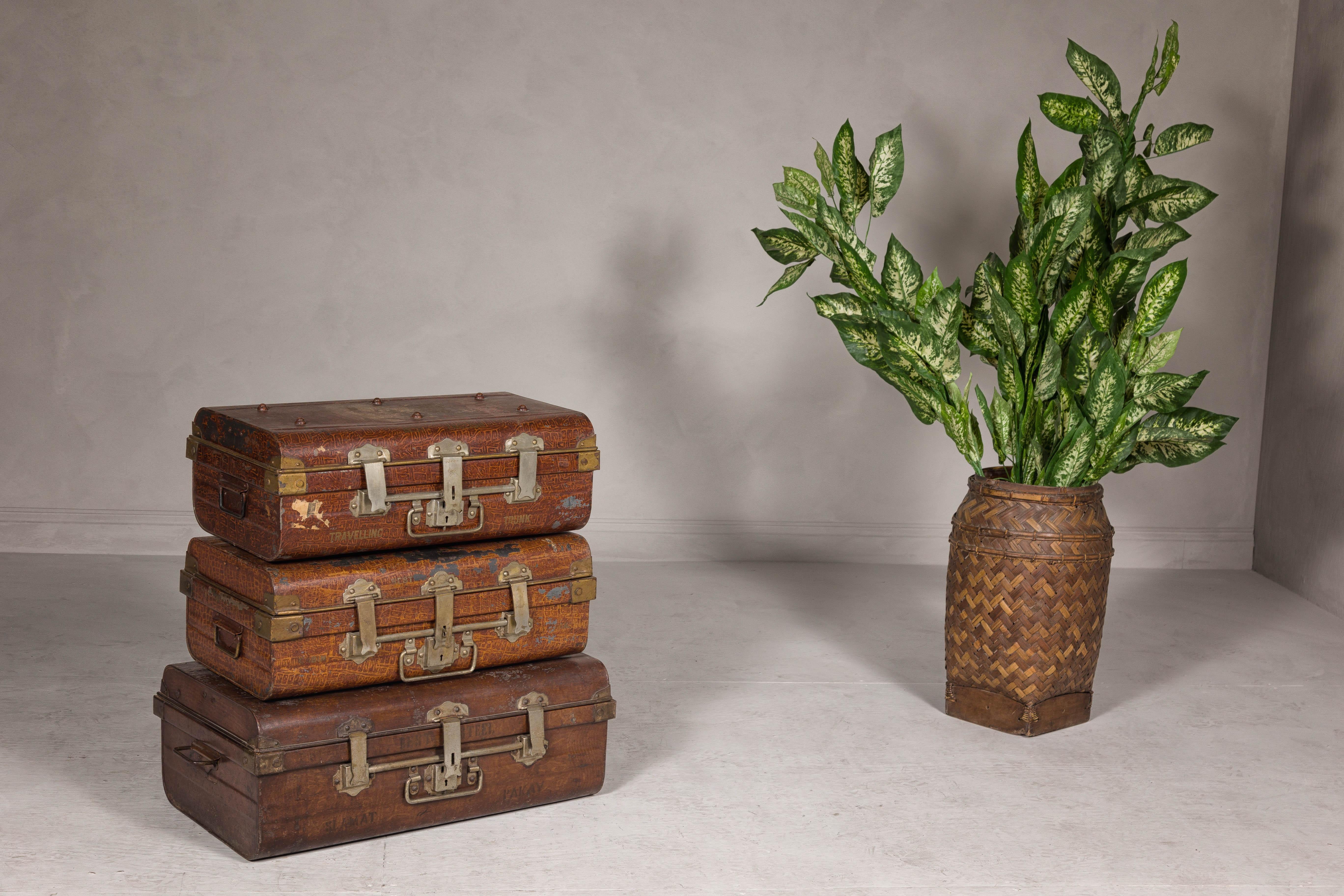 A set of three British suitcases from the early 20th century made for Export, including a Wilkes & Son, as well as a Warranted Best Steel. This captivating set of three early 20th-century British suitcases, including a distinguished piece by Wilkes