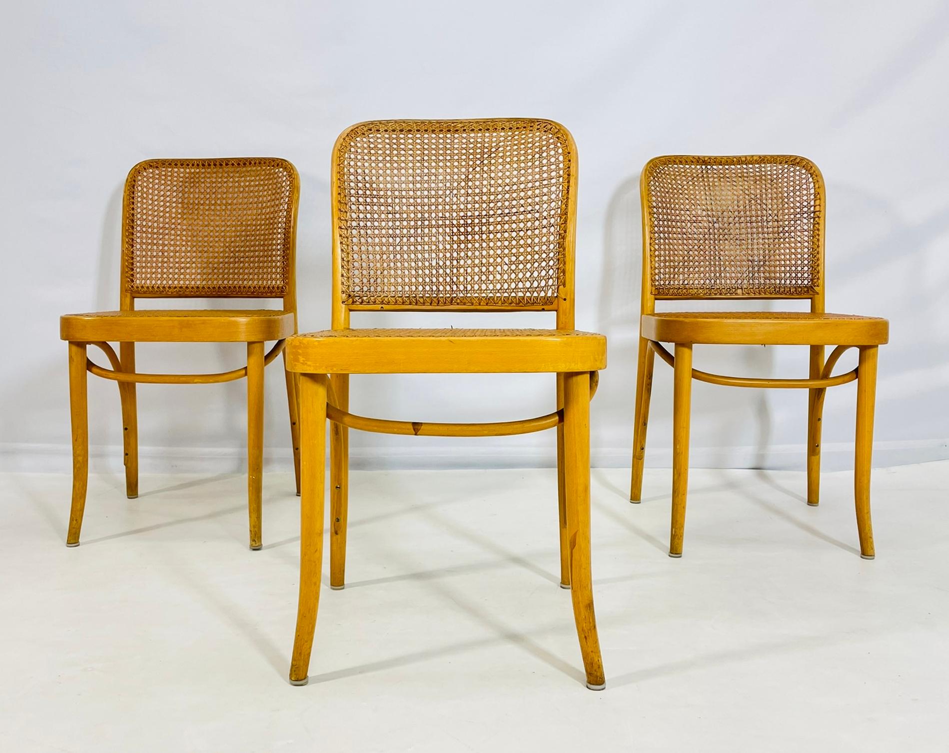  Ensemble de trois chaises Loewenstein/Oggo conçues et fabriquées aux États-Unis dans les années 1960.

 Également connue sous le nom de chaise Thonet, elle se caractérise par sa structure en bois courbé et son assise et son dossier en rotin tressé.