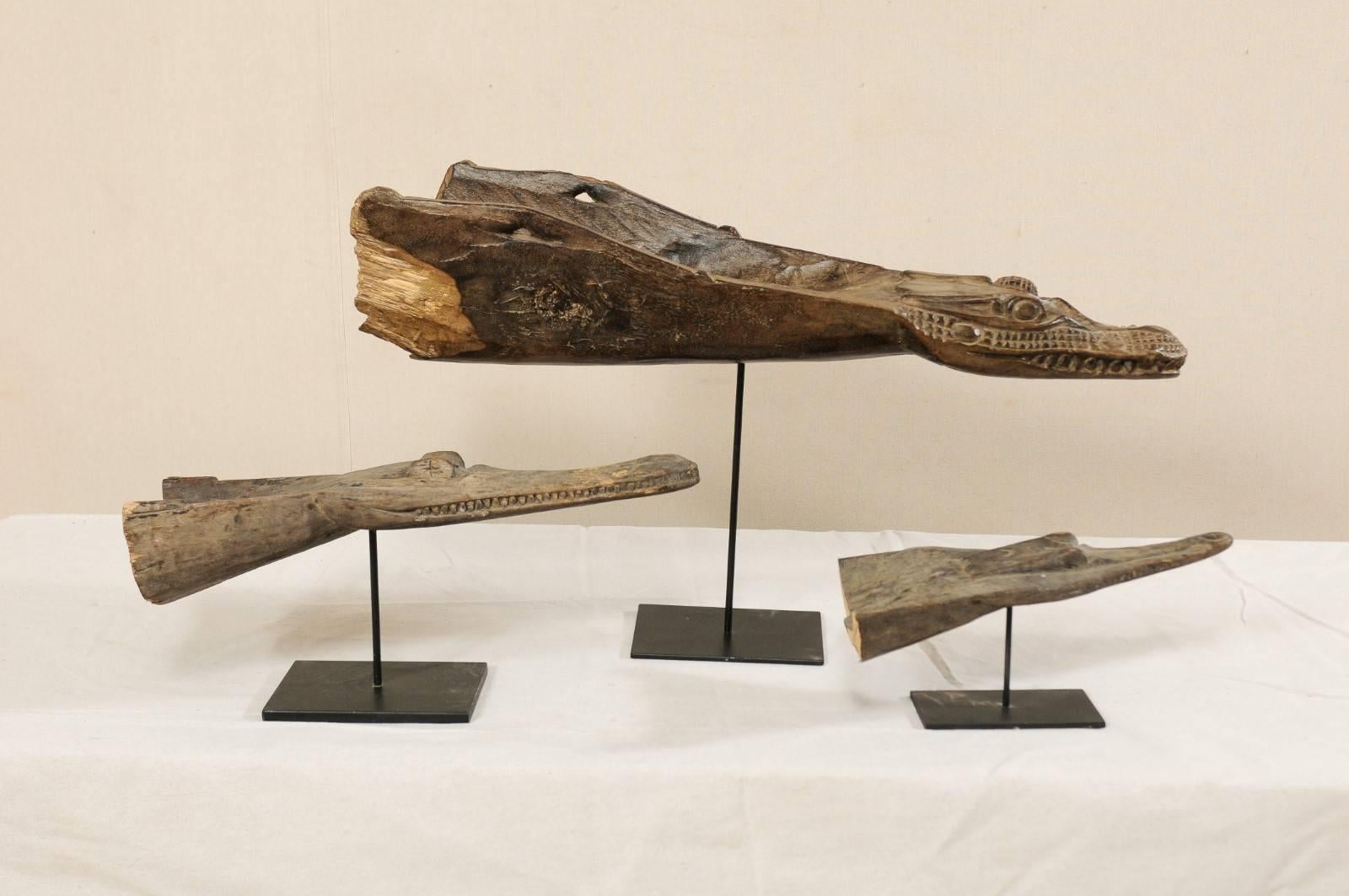 Eine Sammlung von drei holzgeschnitzten Krokodilskopf-Bootstützen aus Papua-Neuguinea. Diese aus der Mitte des 20. Jahrhunderts stammenden Bootsstege aus Papua-Neuguinea sind aus Holz geschnitzt und zeigen jeweils den Kopf eines Krokodils. Sie sind