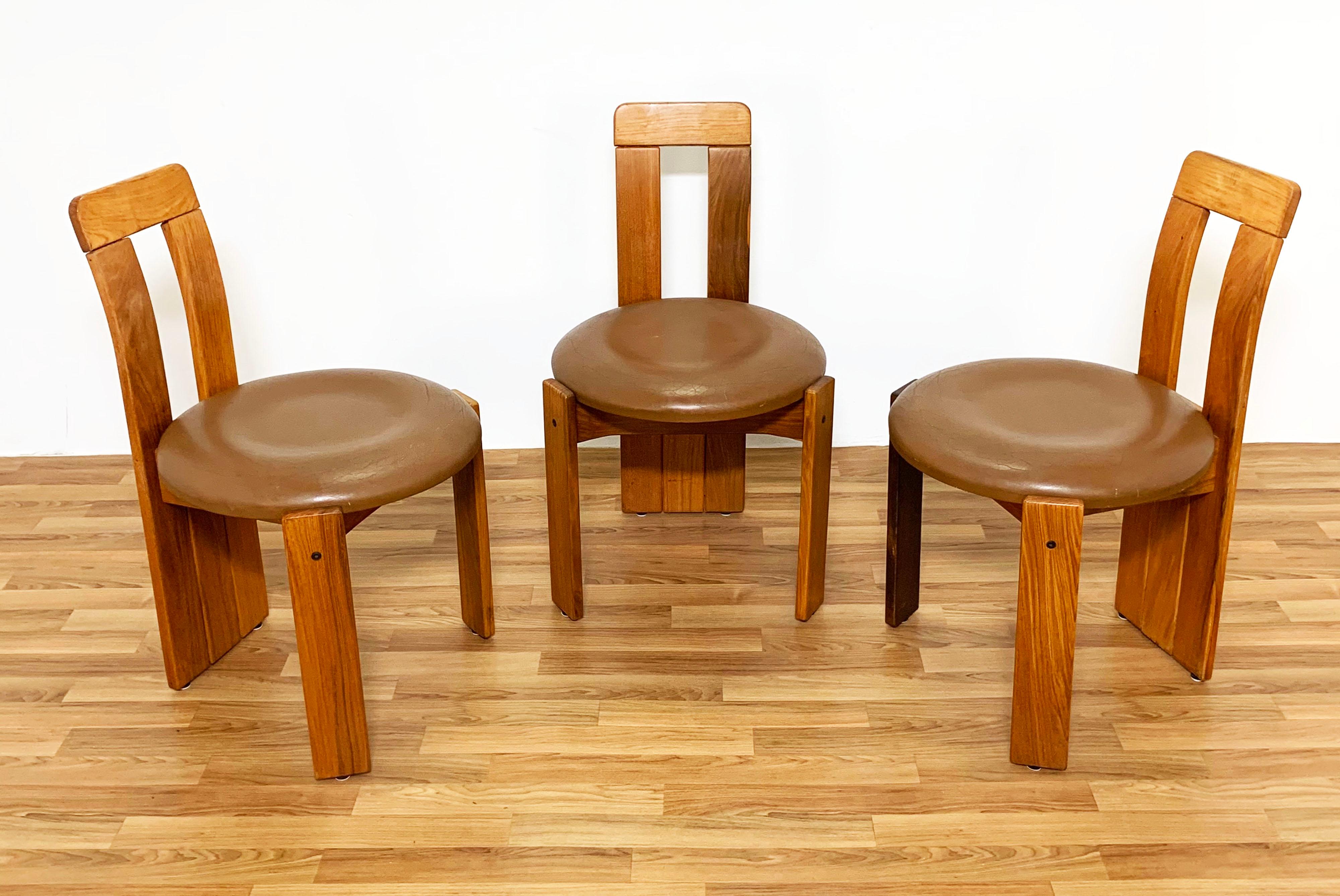 A set of three dining chairs with tripod legs and circular leather seats, circa 1970s. Unmarked, but bear a striking resemblance to the work of either Carlo Scarpa or the prolific team of his son and daughter-in-law, Tobia and Afra.