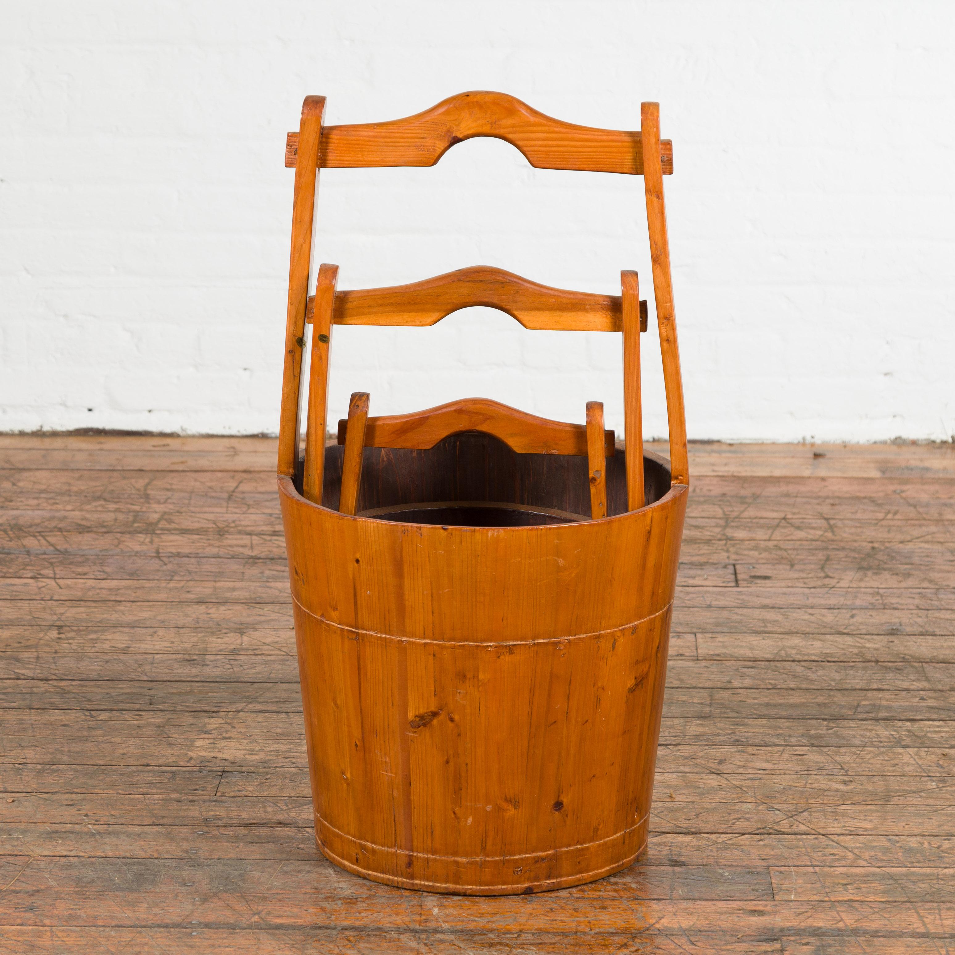 A set of three Chinese vintage grain nested baskets from the mid-20th century, with large handles. Created in China during the midcentury period, each of this set of three grain baskets features a circular tapering body topped with a large handle.