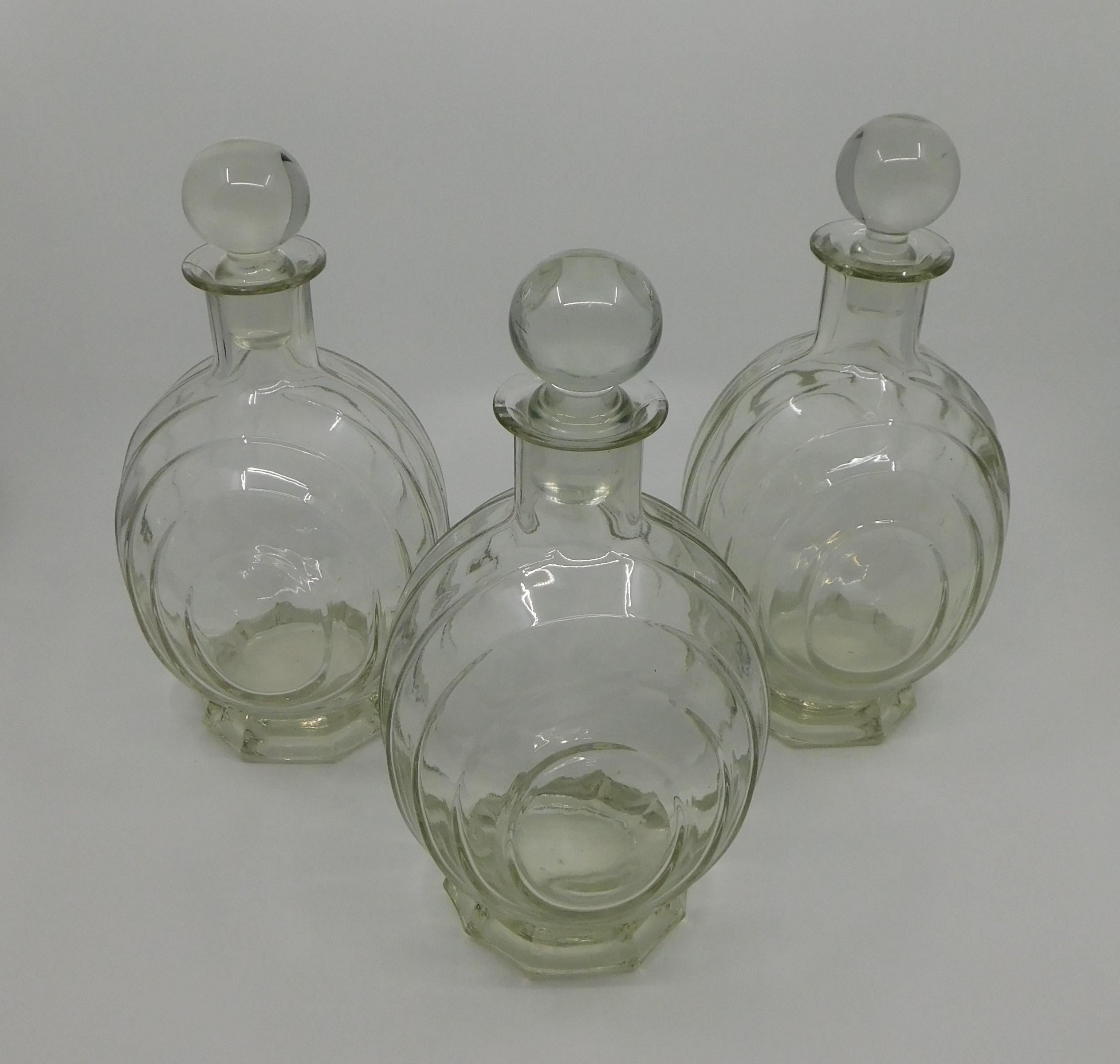 Set of four three circa 1930 clear glass liquor decanter bottles with clear original stopper tops.