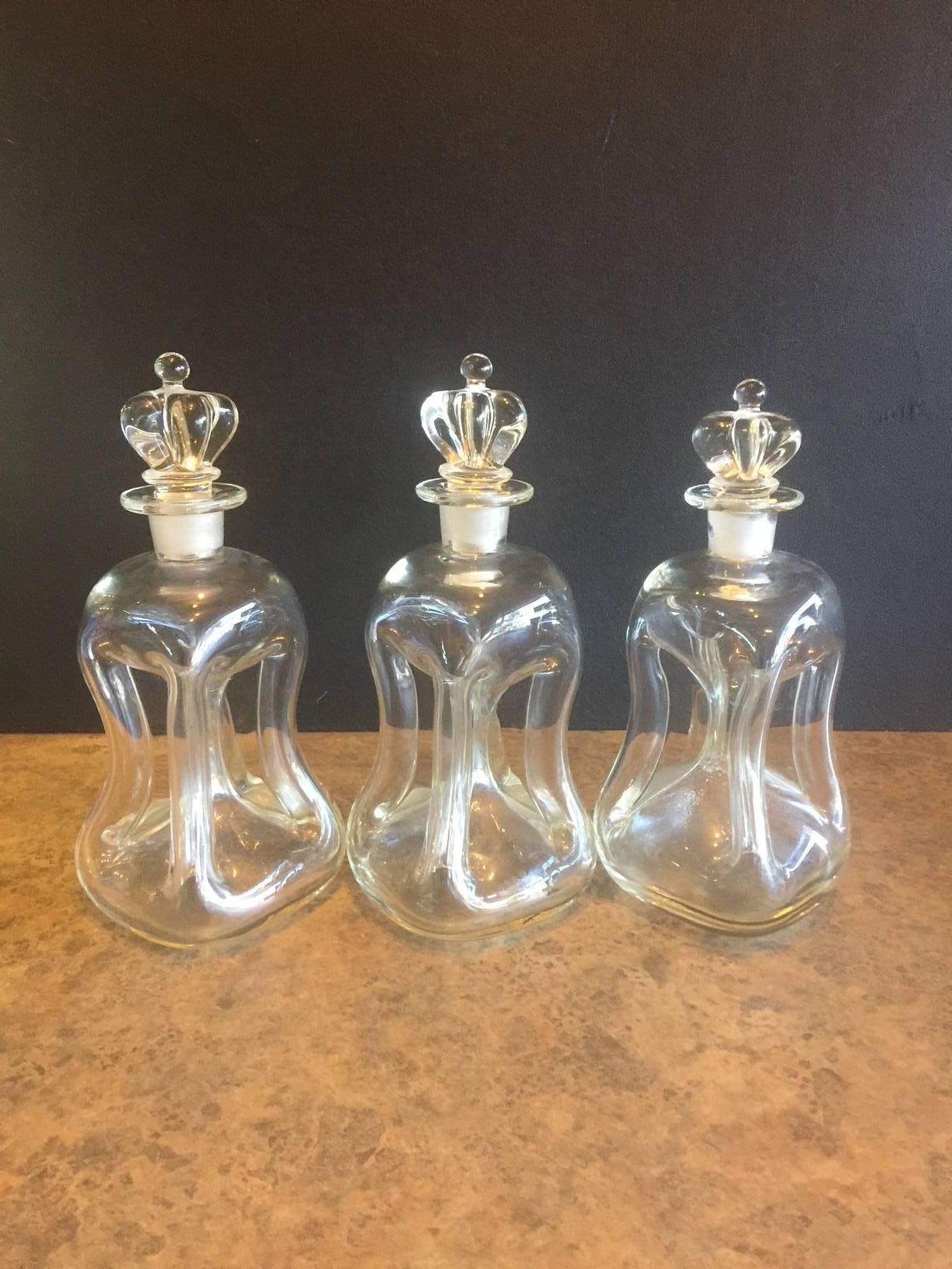 Set of three iconic Danish Holmegaard four-column pinched decanters, circa 1950s. Known as the 