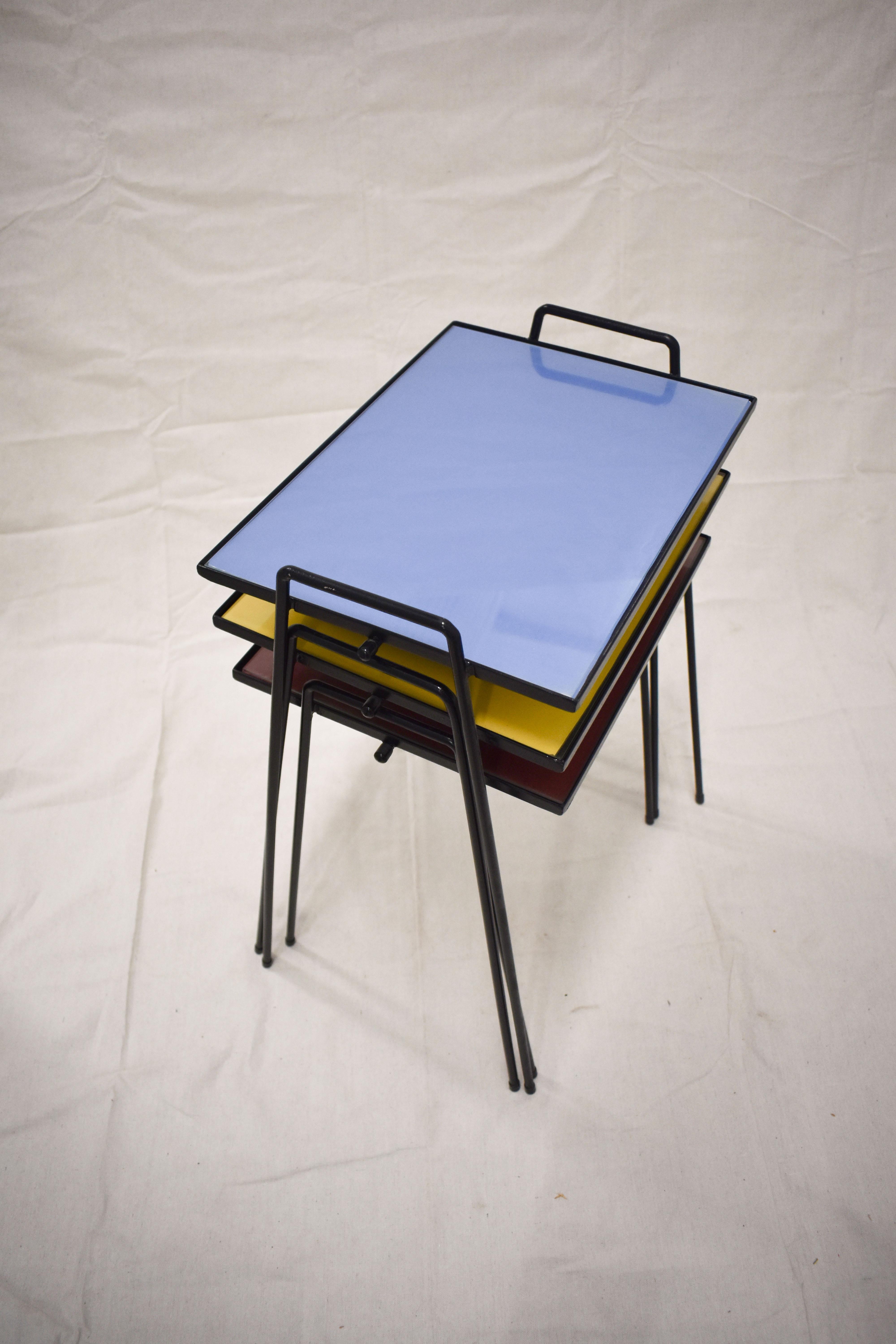 Danois Ensemble de trois tables empilables colorées du milieu du siècle dernier, avec plateau en verre et pieds en fer en vente